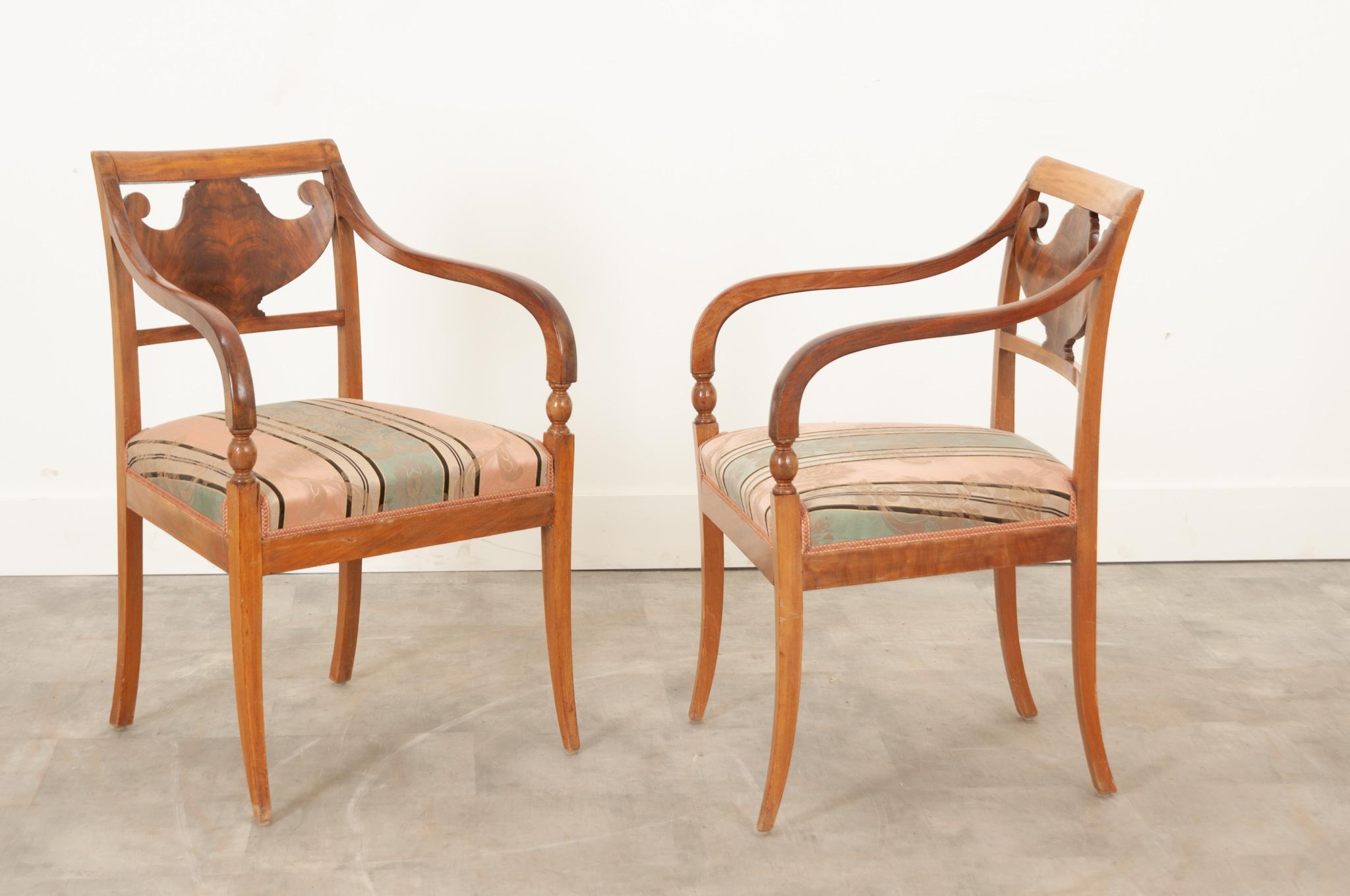 A gorgeous pair of satinwood armchairs, made in The Netherlands during the 19th century. Influenced by English Regency and French Empire styles, the pair have a delightful, delicate design that is airy and light, but also proud and resolute. Each
