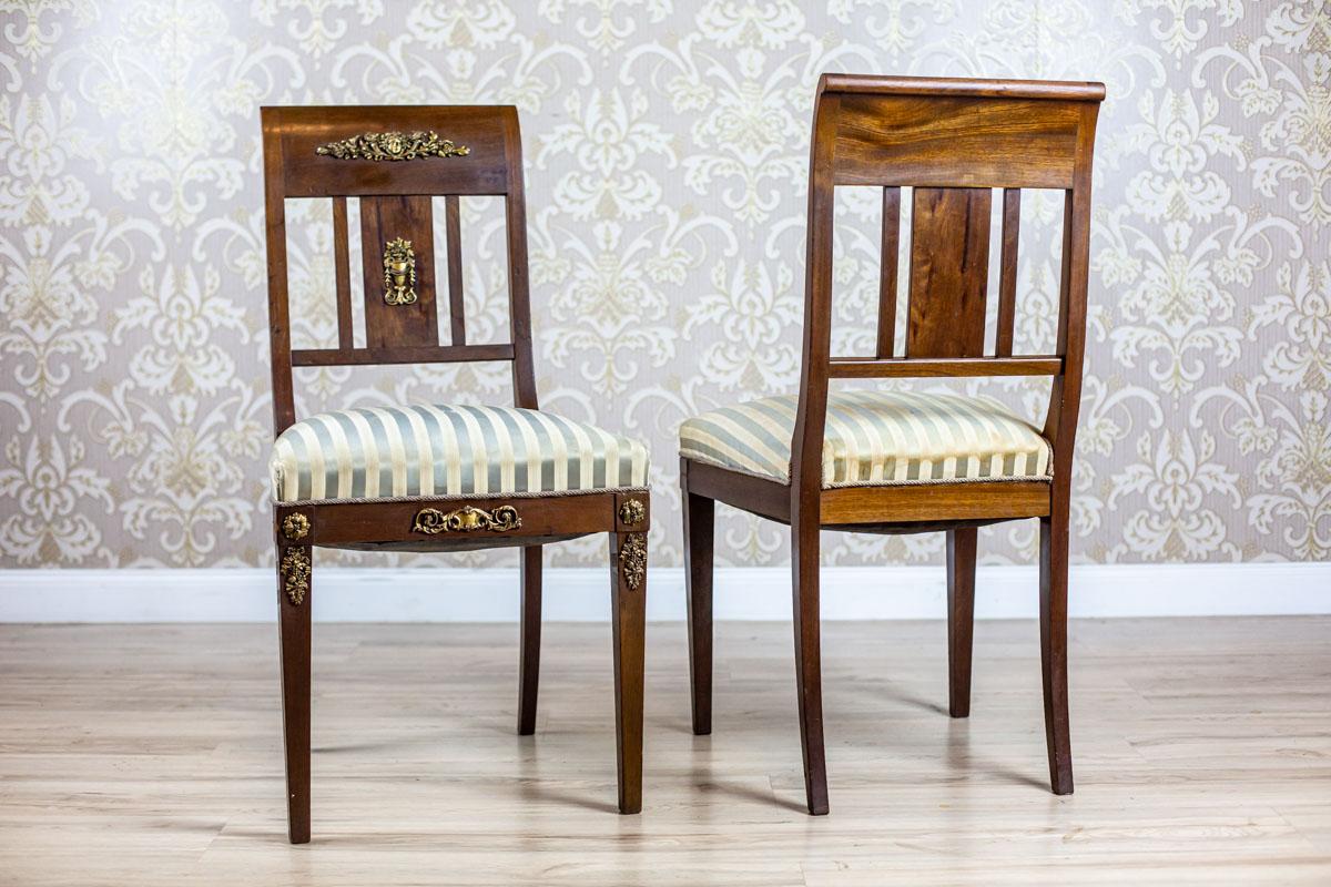 We present you two chairs of a simple form, which is varied by brass appliqués.
The rails of the rectangular backrests are slightly titled backwards.
There are also three vertical slats.

These chairs have not undergone renovation but are in good