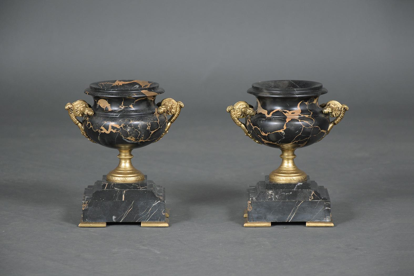 This pair of black gold marble color empire urns are beautifully handcrafted, with large brass handles and accents, and are ready to be used in any home for years to come.
