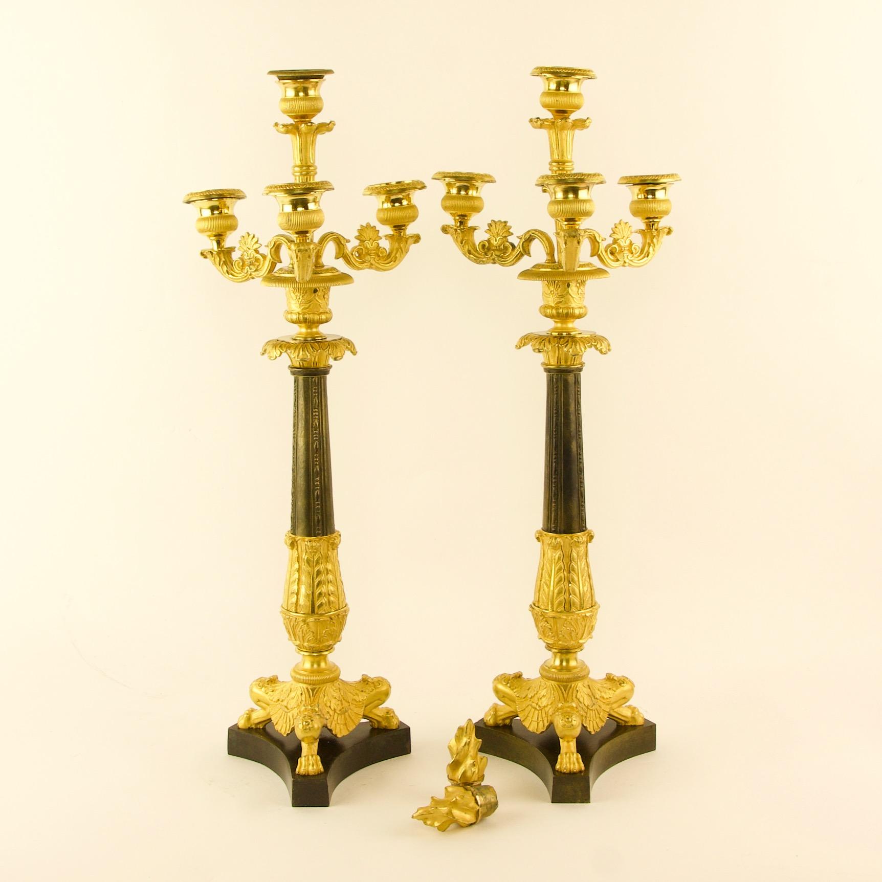 Pair of 19th century Empire ormolu and patinated bronze candelabra attr. Thomire

Each with a tapering leaf tip cast partially gilt and patinated bronze stem supporting three foliate carved candle branches with vase-shaped bobeches and removable