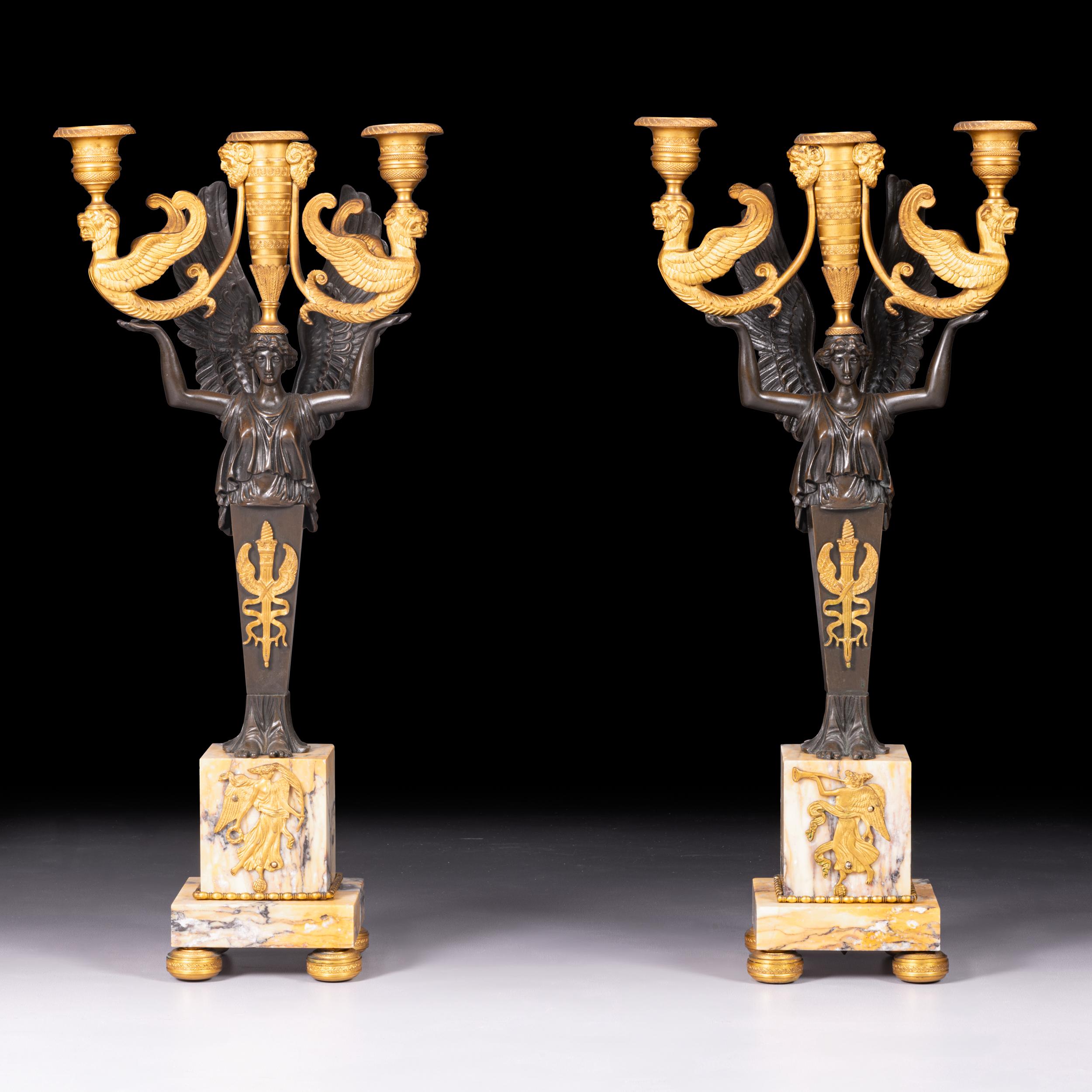 Una splendida e attraente coppia di candelabri a tre luci in stile impero 