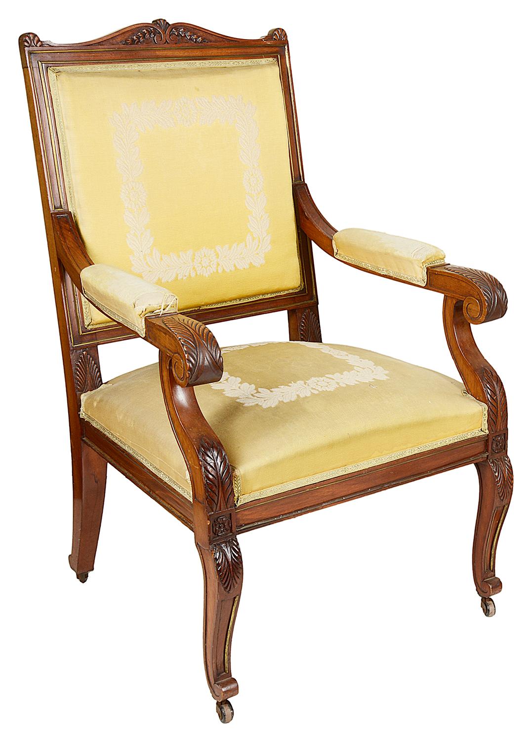 A good quality pair of French Mahogany Empire influenced arm chairs. Each with classical scrolling leaf decoration, brass trimming, upholstered stuff over back and seats and raised on carved scrolling cabriole legs.