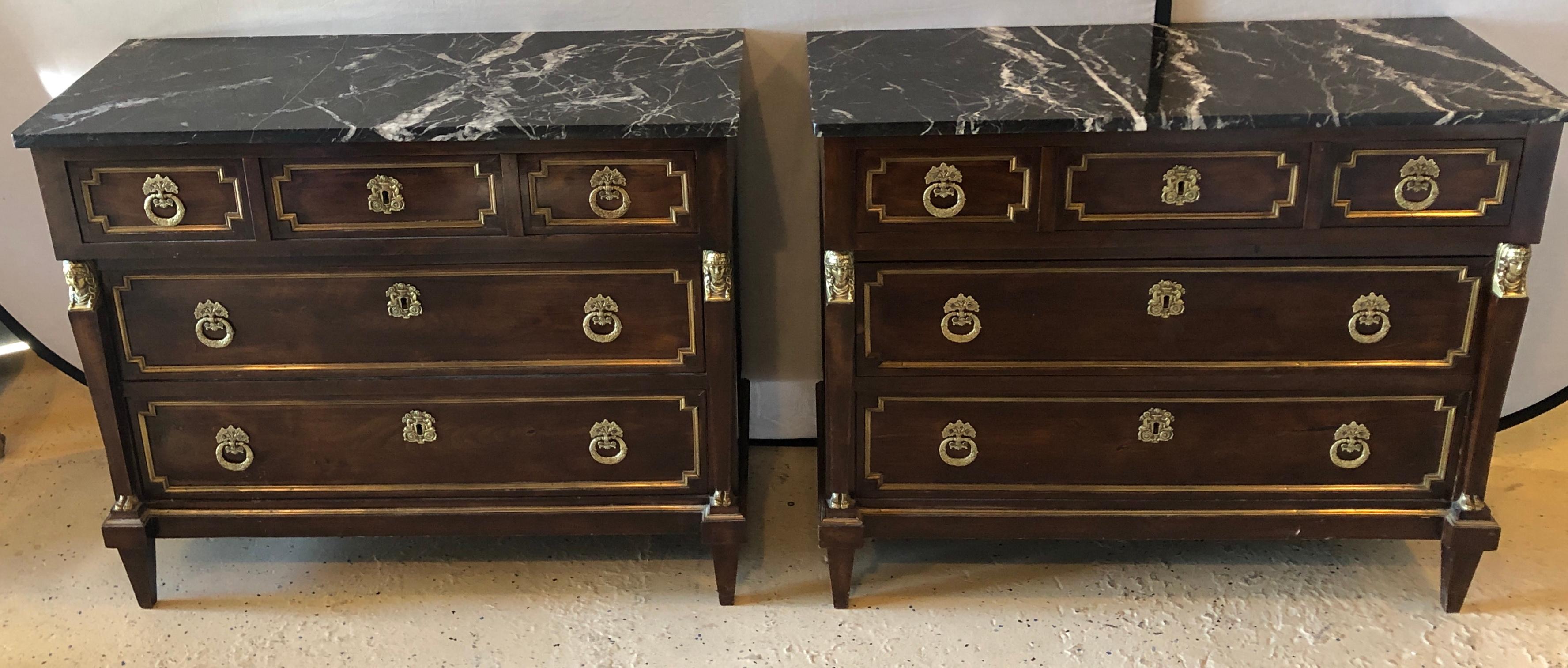 Pair of 19th century Empire style commodes or nightstands. Each having three bronze framed drawers with bronze floral pulls flanked by bronze and wooden bodied woman. The whole supporting black and white veined marble tops.