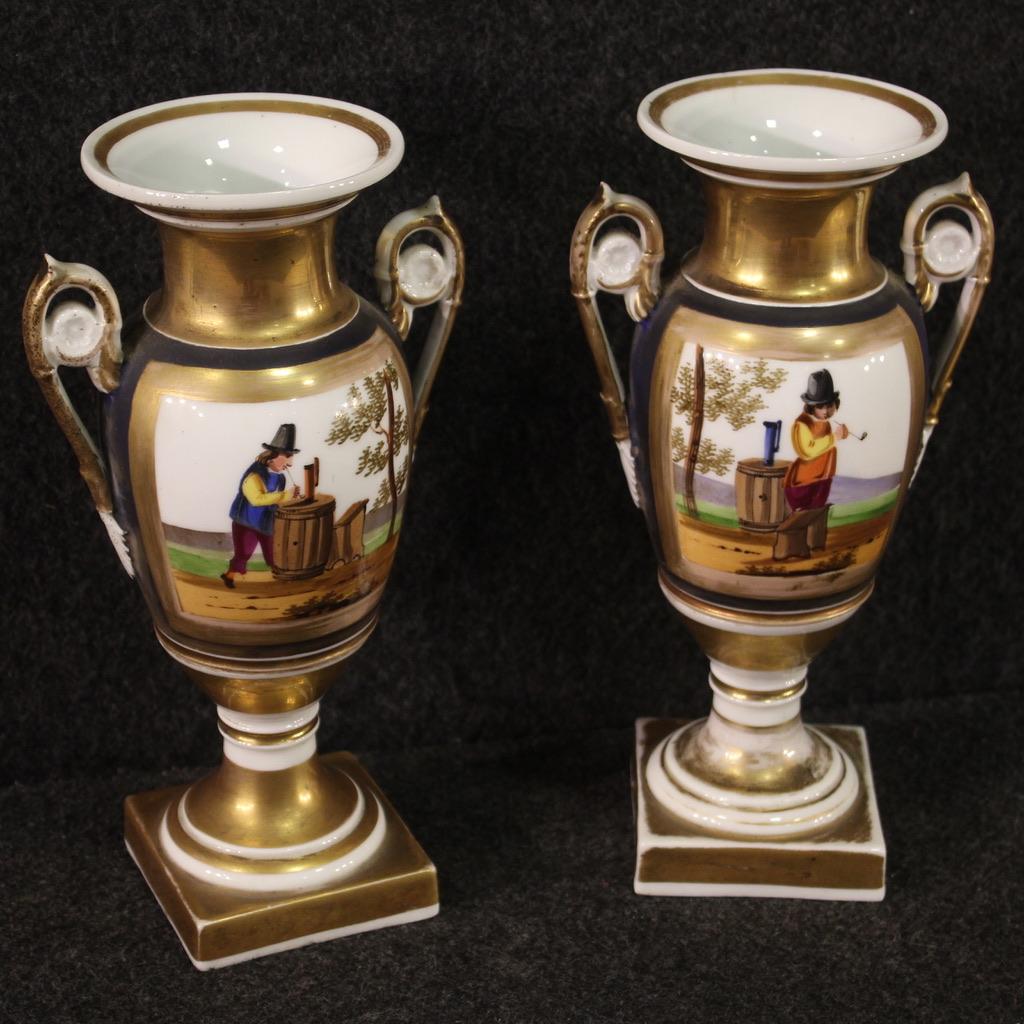 Pair of French Empire vases from the second half of the 19th century. Objects of good size in gilded and hand painted ceramic with scenes of popular taste of good quality. Vases finished from the center with chiseled and gilded handles, stamped