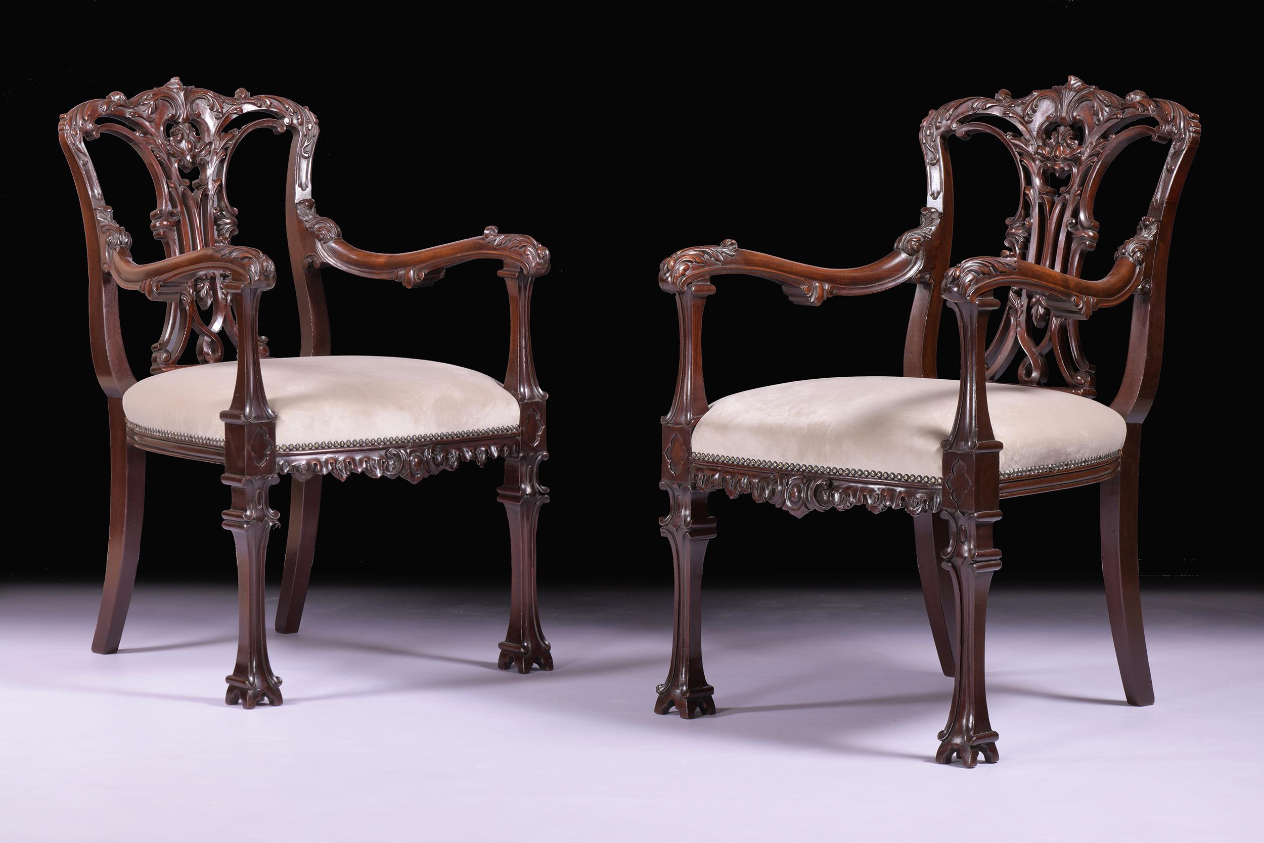 A beautiful pair of 19th century armchairs in the Chinese Chippendale taste, the domed crest above an elaborately carved and interlaced ribbon splat, joined by an upholstered padded seat and scrolling arms, the front legs terminating in 'Chinese'