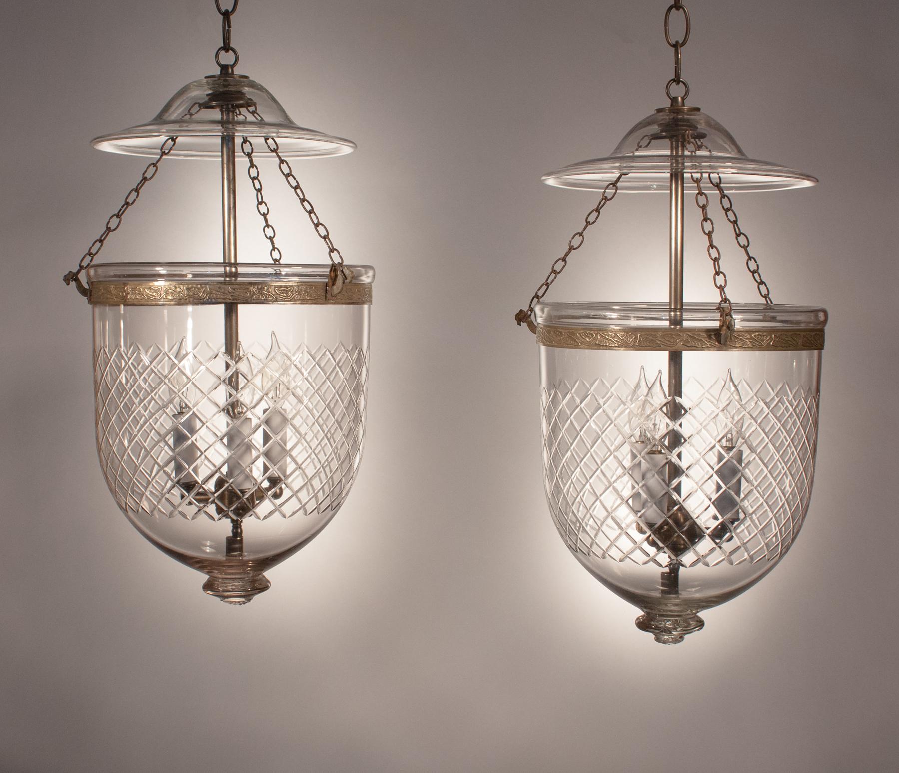 It is rare to find a pair of authentic bell jar lanterns with such great quality handblown glass that are also this well matched. These circa 1875 medium-sized lanterns are cut with a Waterford-like diamond motif and feature period smoke bells and