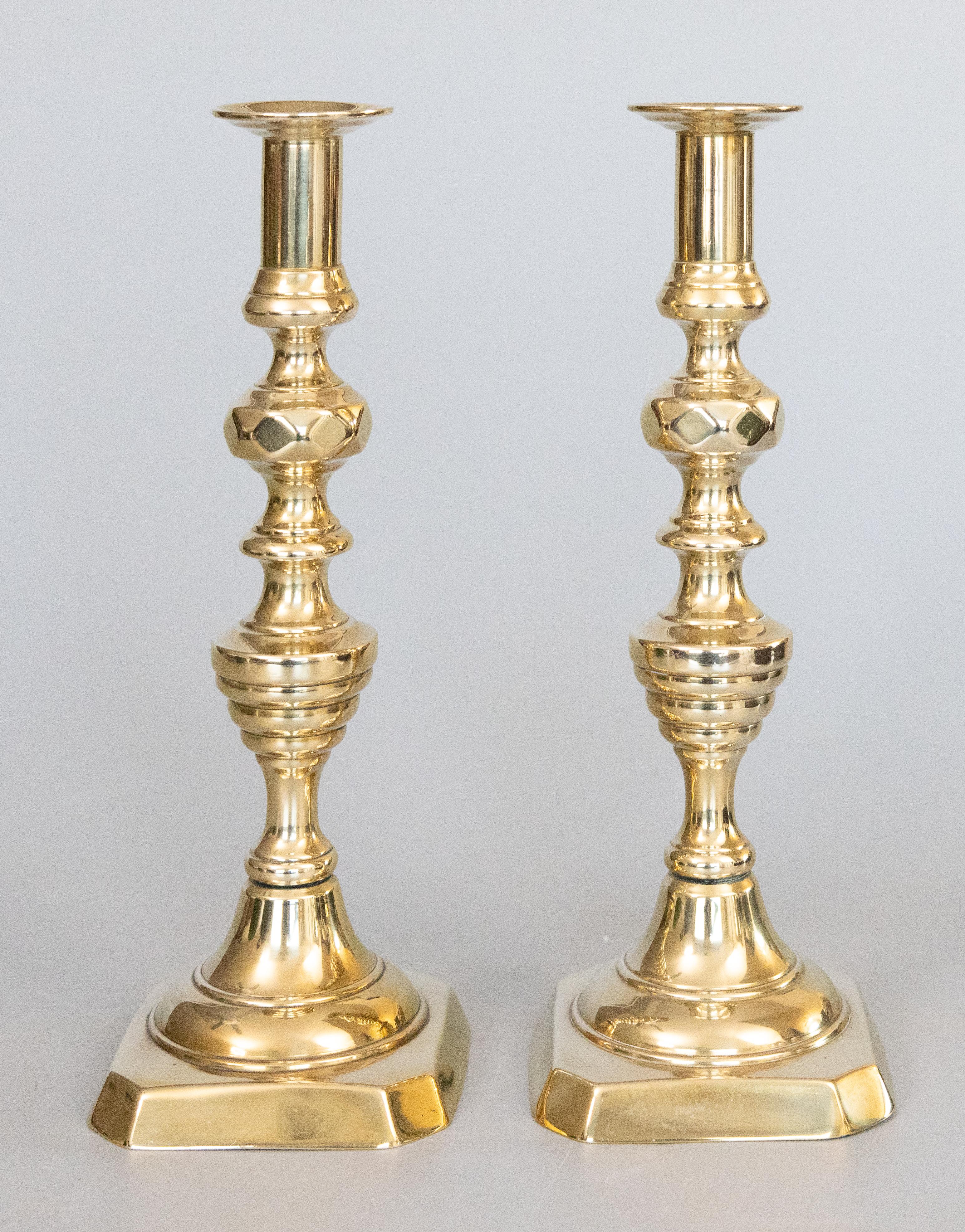Una bella coppia di antichi candelieri ad espulsione in ottone massiccio del XIX secolo con motivi ad alveare e diamanti, circa 1880. Ognuno di essi conserva ancora l'asta di espulsione originale. Questi bei portacandele sono solidi e pesanti, con