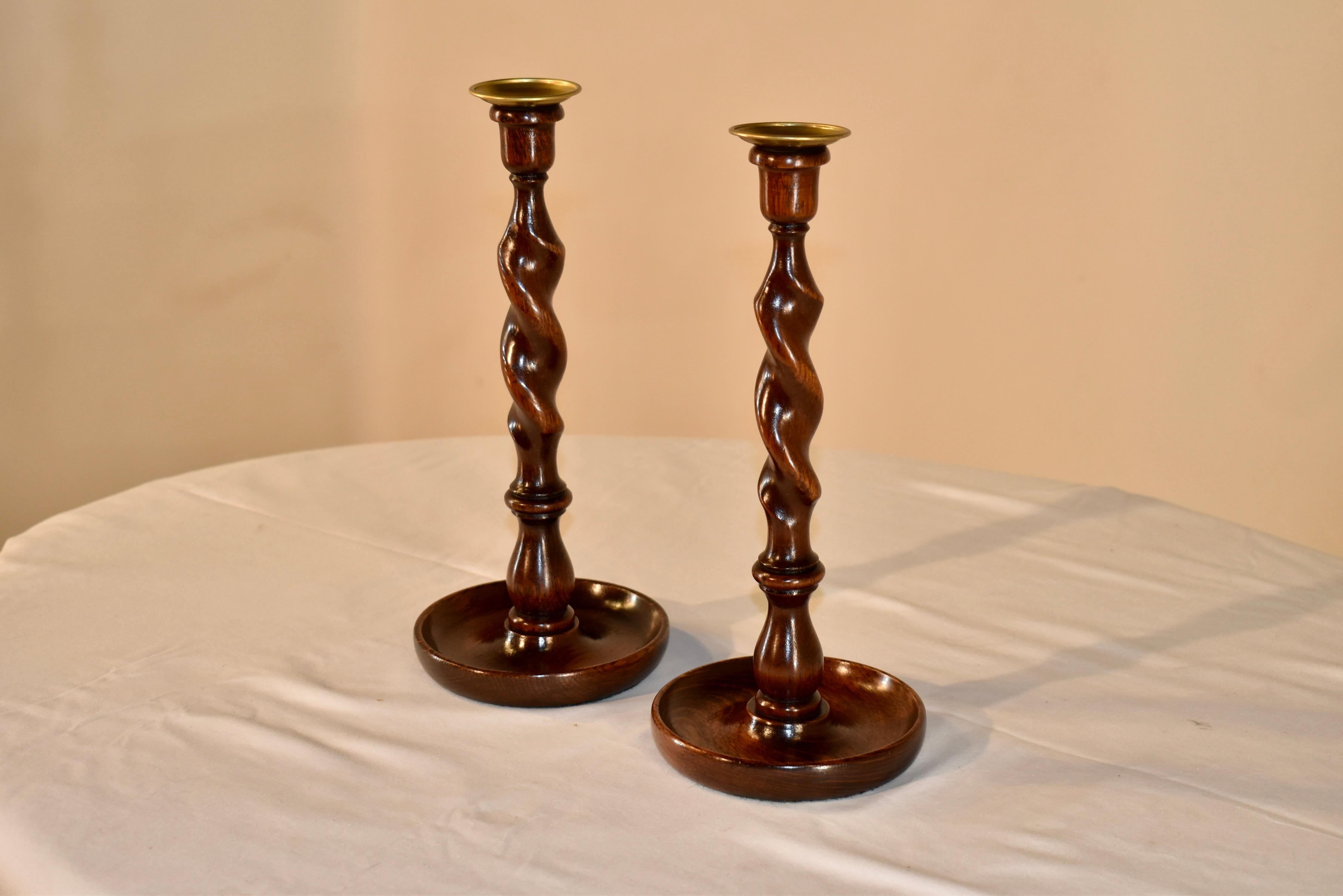 Pair of 19th century oak candlesticks from England. The bobeches are hand turned brass, following down to hand turned candle cups, which are supported on turned barley twist stems, resting on hand turned dish shaped bases. Lovely turning and height.