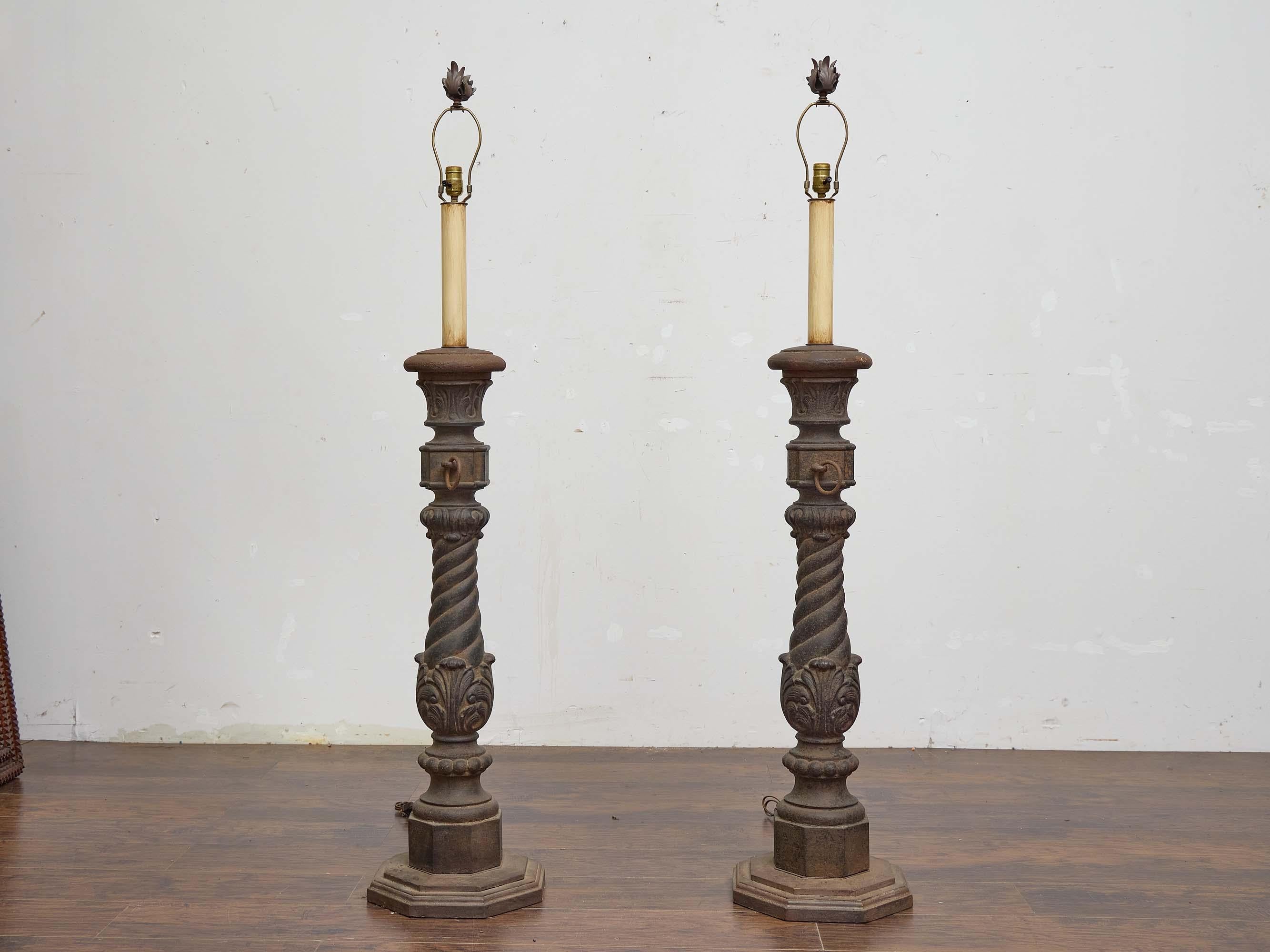 This impressive pair of 19th-century English lamps is fashioned from heavy cast iron, repurposed from original hitching posts once used for securing horses in front of estates and townhouses. Each piece retains the distinctive square midsection