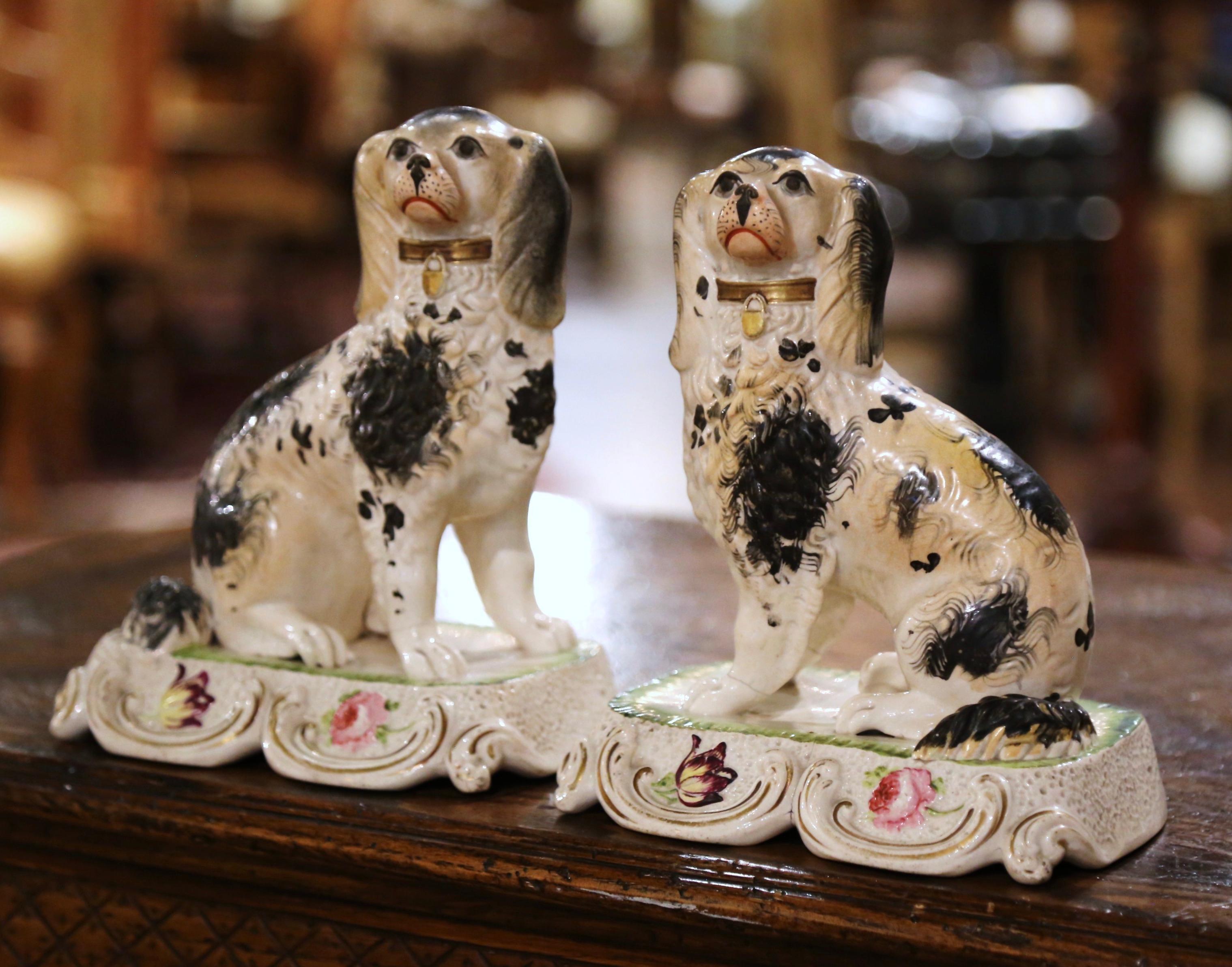 Add a touch of vintage charm to your mantel, tabletop, or bookshelf with this pair of antique porcelain Staffordshire spaniels. Crafted in England circa 1880, this pair of black and white dogs showcase a gold gilded collar, creating a visually