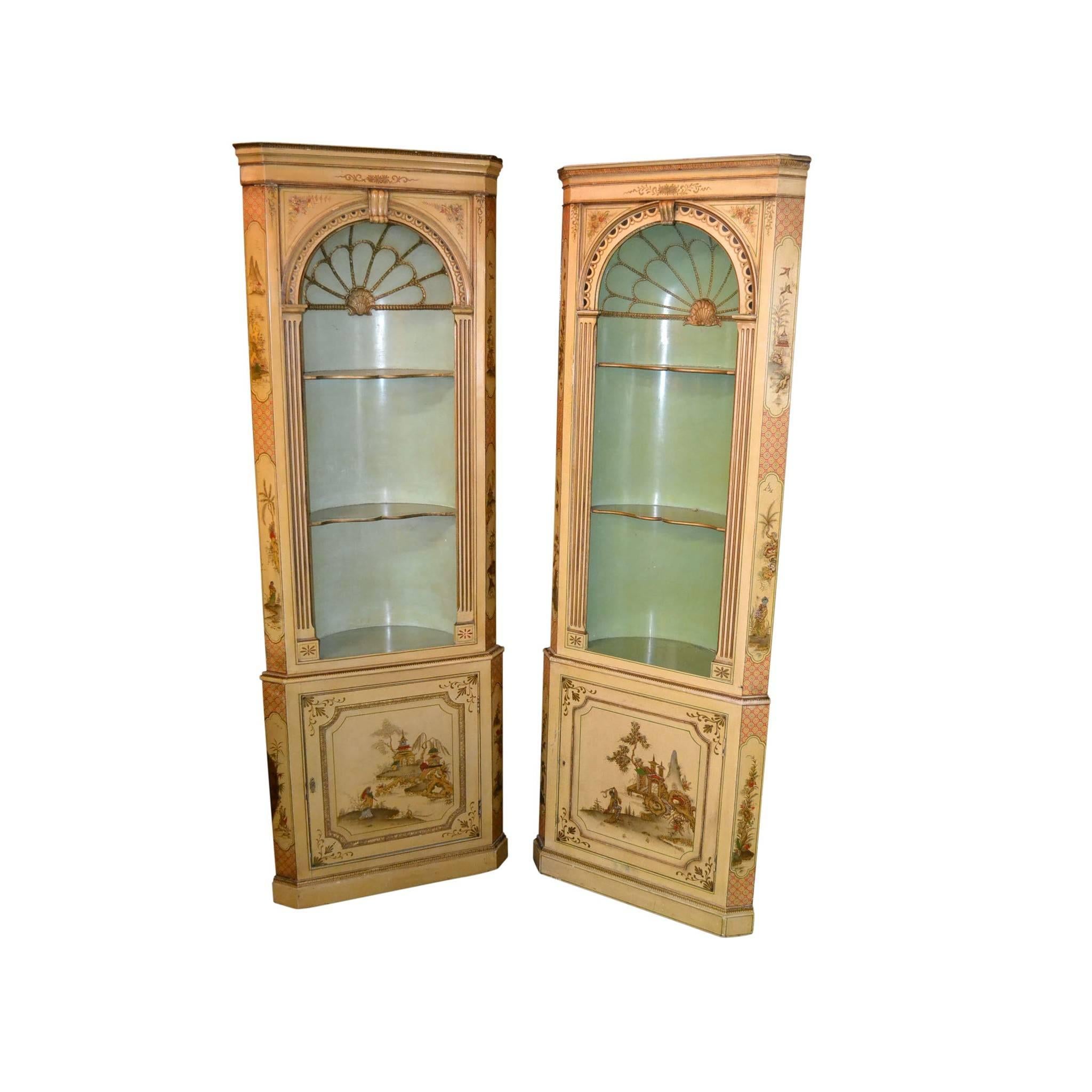 Fabulous pair of 19th century English corner cabinets with partially domed interiors with shell carvings and contoured shelves. Each with superb overall pale yellow Chinoiserie decoration depicting treed and flowering landscapes with pagodas and