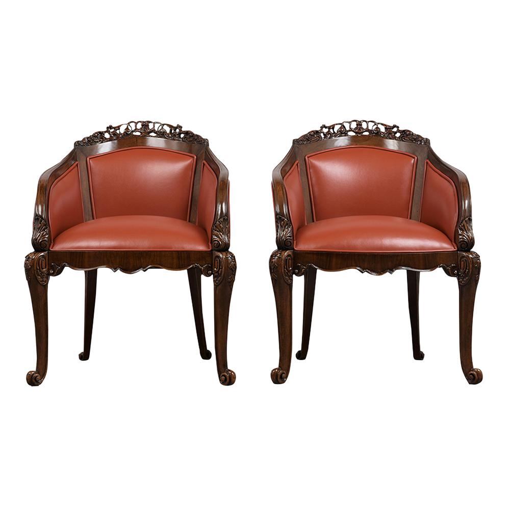 This pair of late 19th century English Chinoiserie style bergères have been restored and professionally upholstered in a cognac color leather with single piping detail. The frames are made out of solid walnut wood stained in a rich walnut color with