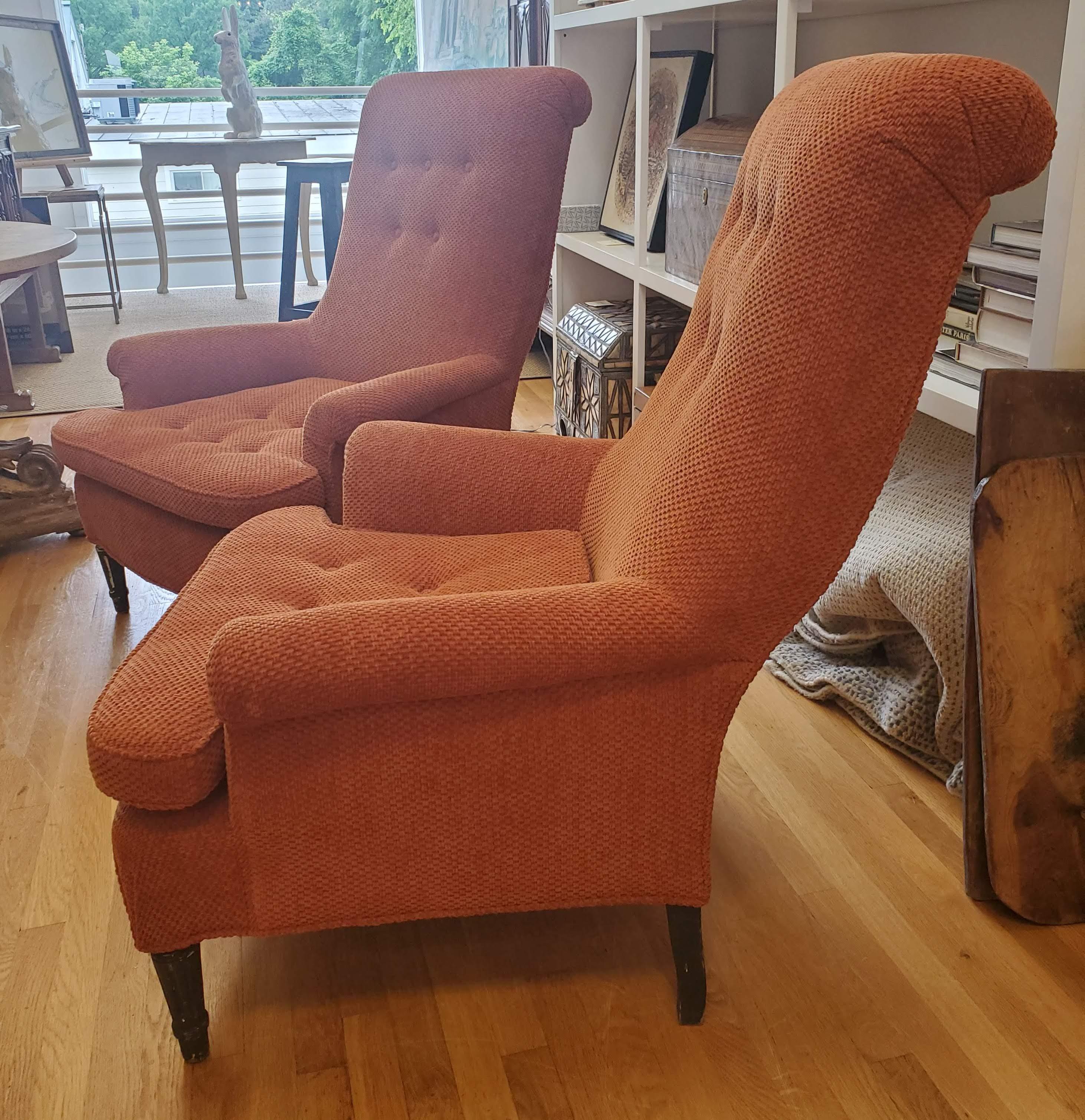 This pair of 19th century English club chairs will make a lovely sturdy and structural addition to your sitting room. With rolled arms and back and button decoration, these chairs, upholstered in an orange chenille fabric, are fun and sophisticated.