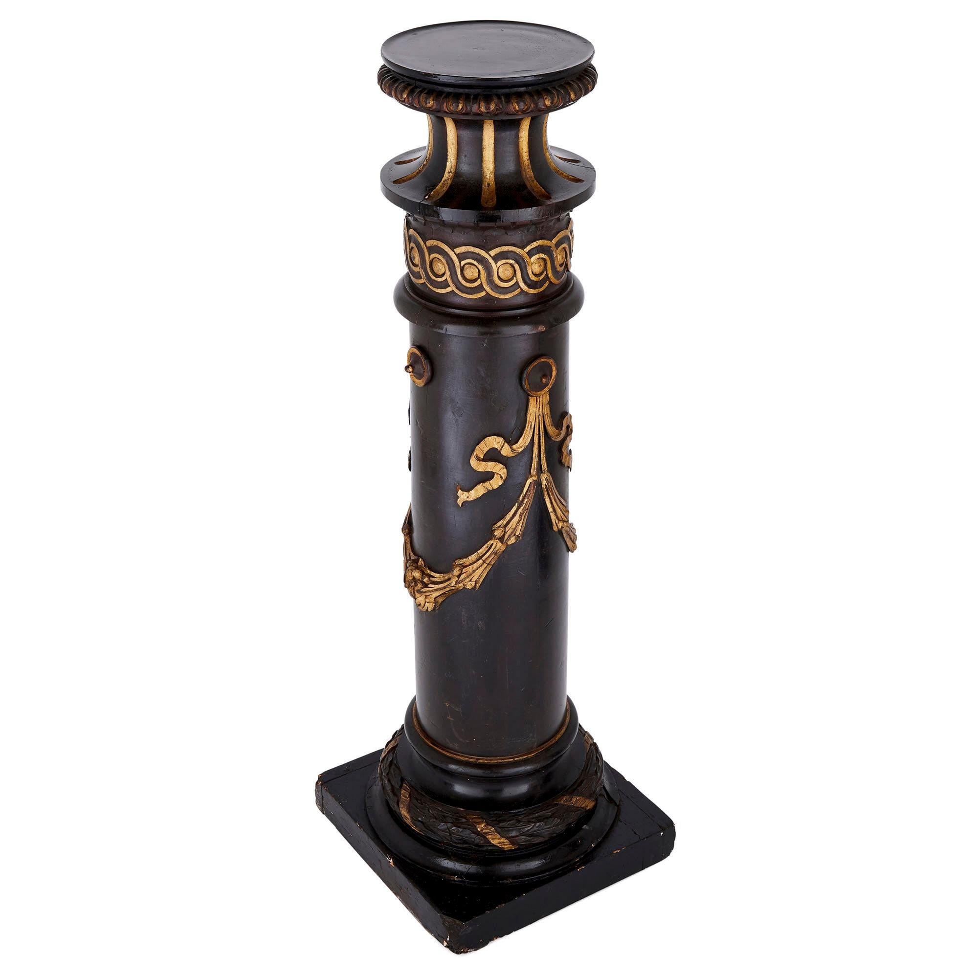 This pair of Victorian period columns is formed from ebonised and giltwood. Each column mimics the form of a Classical column, complete with base, torus, shaft, and capital. Each column stands on a square base, rising to a laurel wreath form torus,