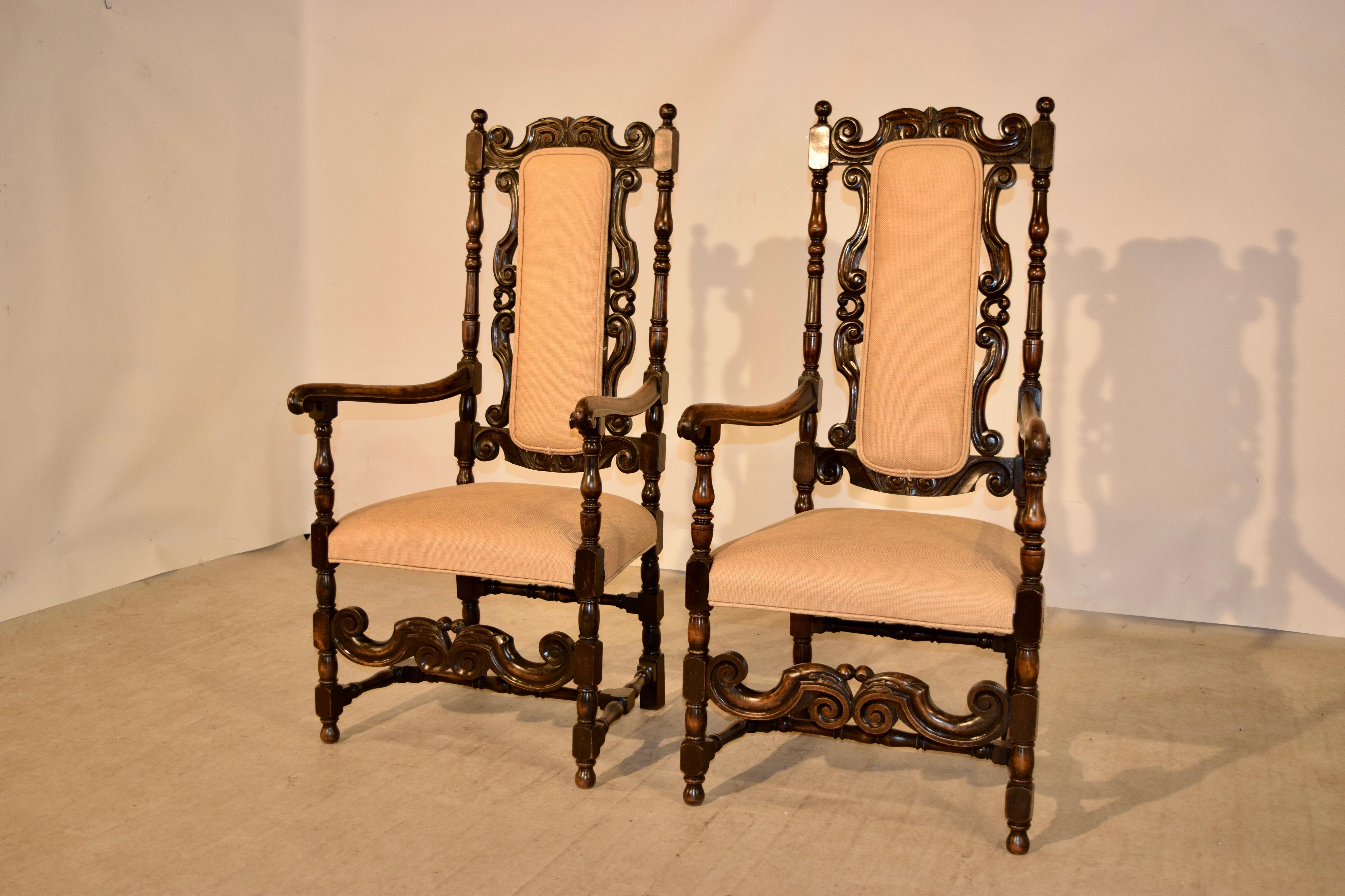 Pair of 19th century oak hall chairs from England. They have wonderfully hand carved backs with hand turned frames. We have had the seats and backs newly upholstered in linen.