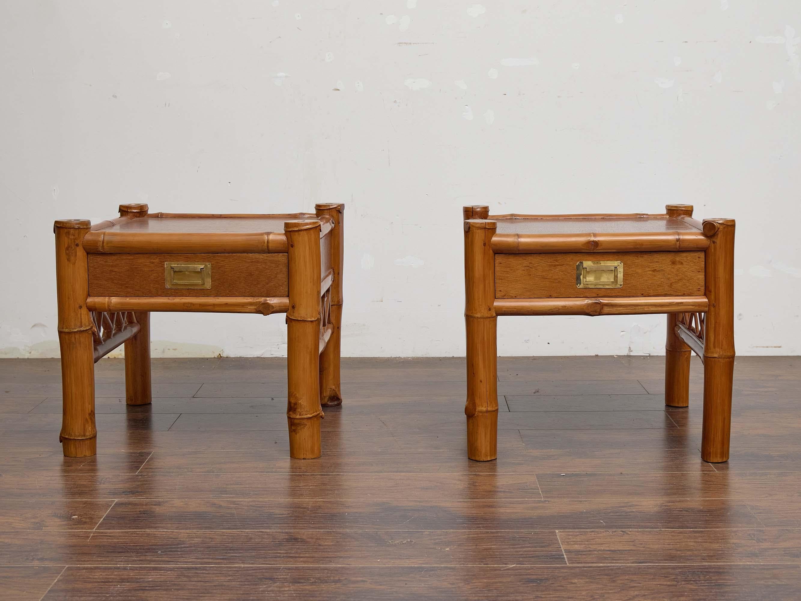Rare et charmante paire de tables d'appoint anglaises du XIXe siècle combinant l'acajou et le bambou dans un design qui équilibre le flair exotique et la fonction pratique. Chaque table carrée est encadrée par des supports et des châssis en bambou