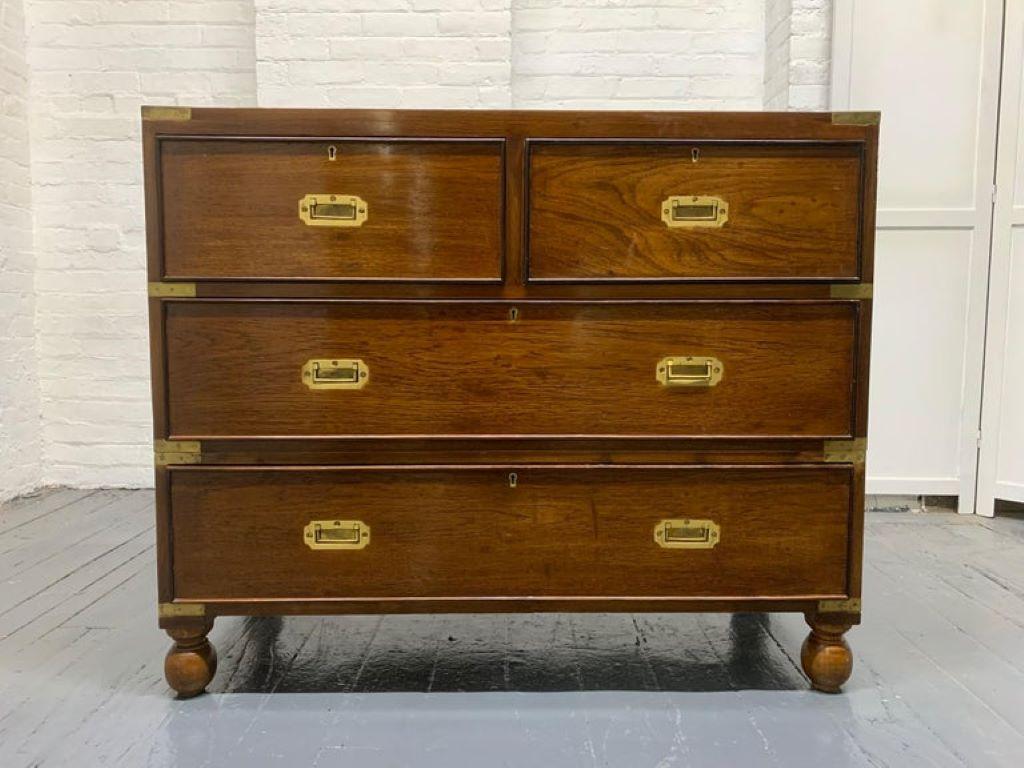 Pair of 19th century English Campaign chests. The chests are mahogany, has ball feet with brass hardware and trim. Comes in two parts (top and bottom). The top has three drawers, and the bottom has a single drawer.
One is slightly taller. Measures