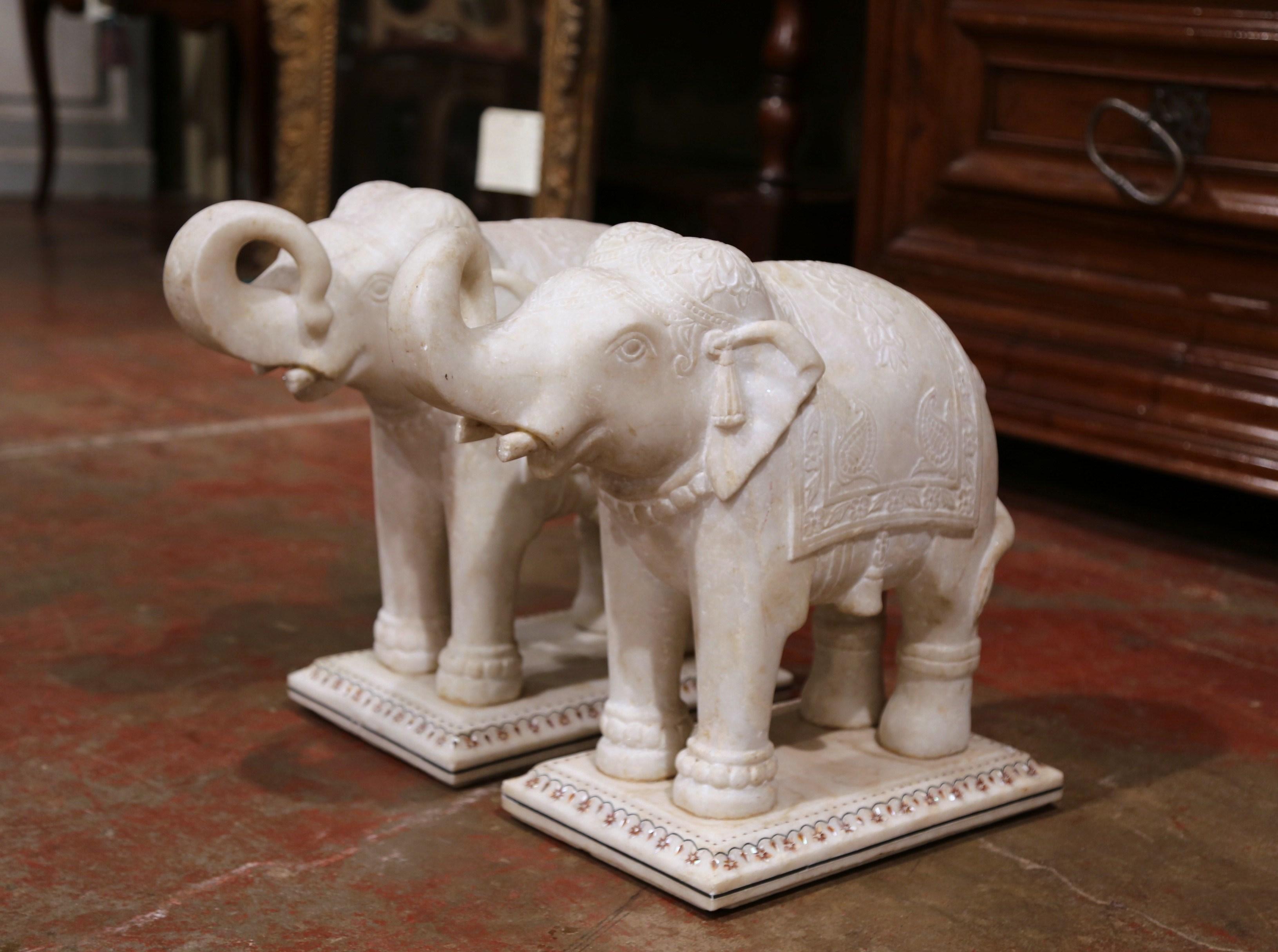 Make a statement in your entry with this pair of antique, marble elephant sculptures. Crafted in England circa 1860, the hand carved mammals stand on a rectangular base embellished with inlaid mother of pearl decor around the edges. Each elephant is