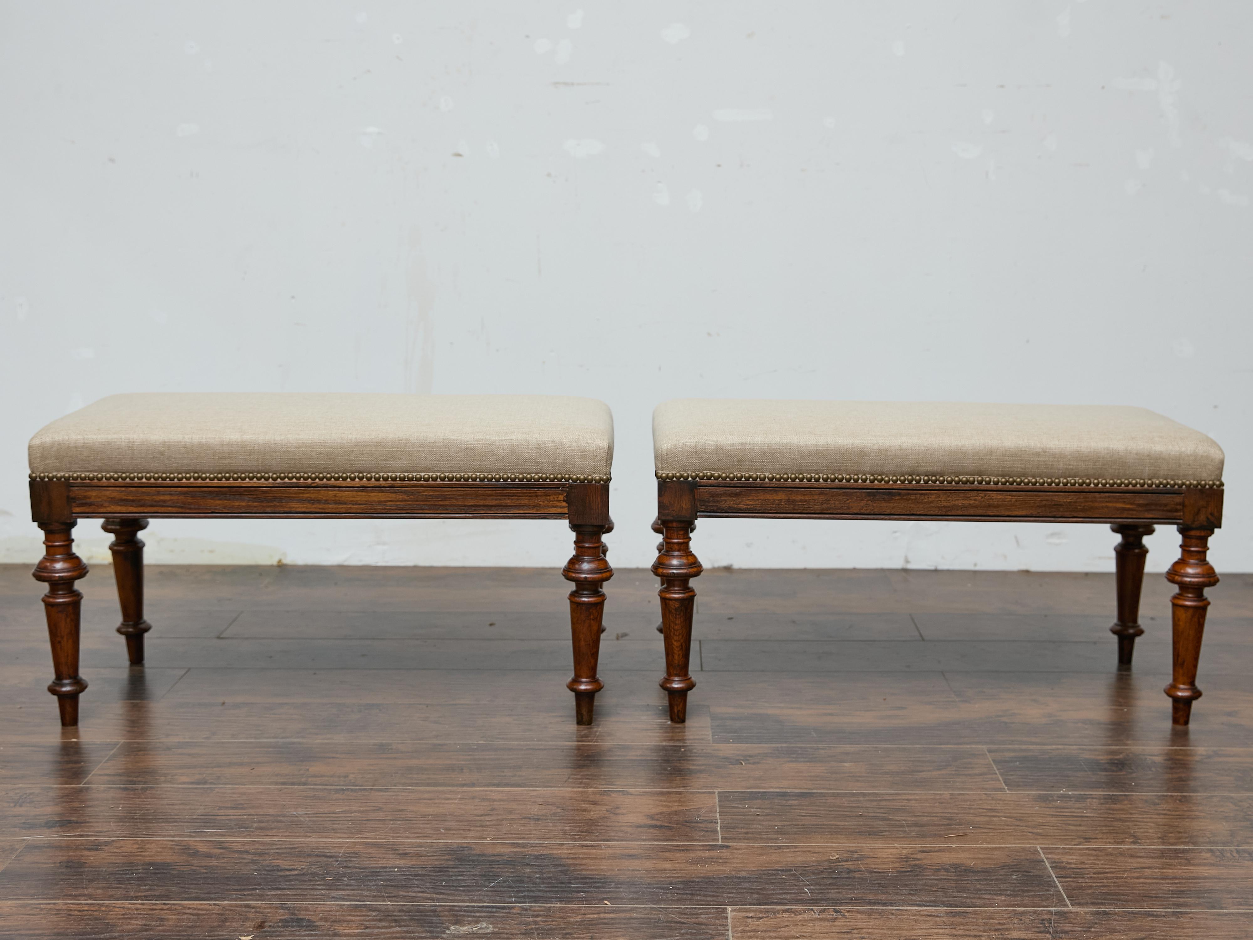 A pair of English 19th century oak benches with turned legs and custom upholstery. This pair of English 19th-century oak benches exudes understated elegance with a timeless silhouette that seamlessly blends traditional craftsmanship with modern