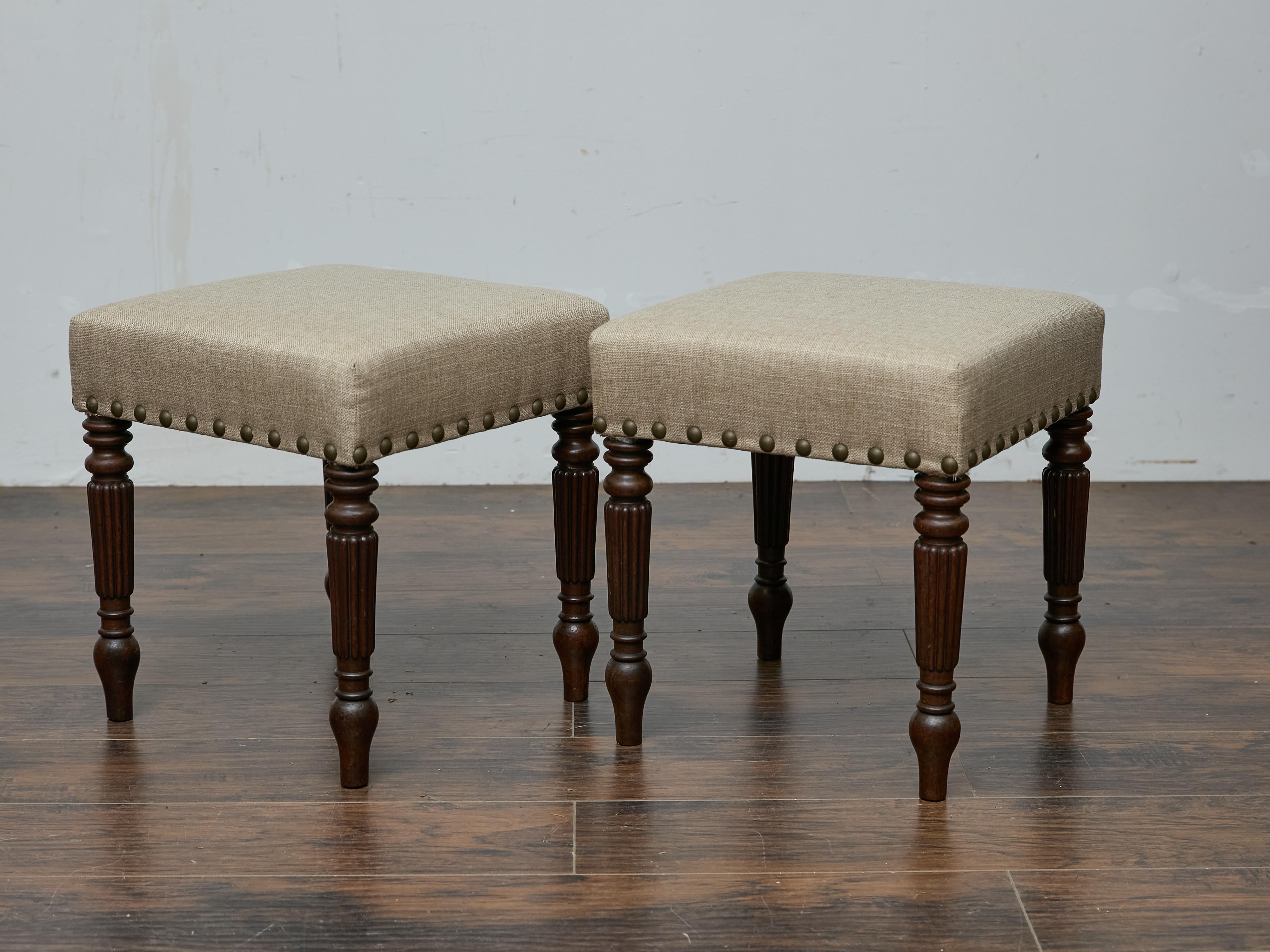 Coppia di sgabelli inglesi in rovere del XIX secolo con rivestimento in lino personalizzato. Le sedute quadrate sono rivestite in un tessuto di lino neutro personalizzato, accentuato da una decorazione in ottone invecchiato che ne esalta il fascino