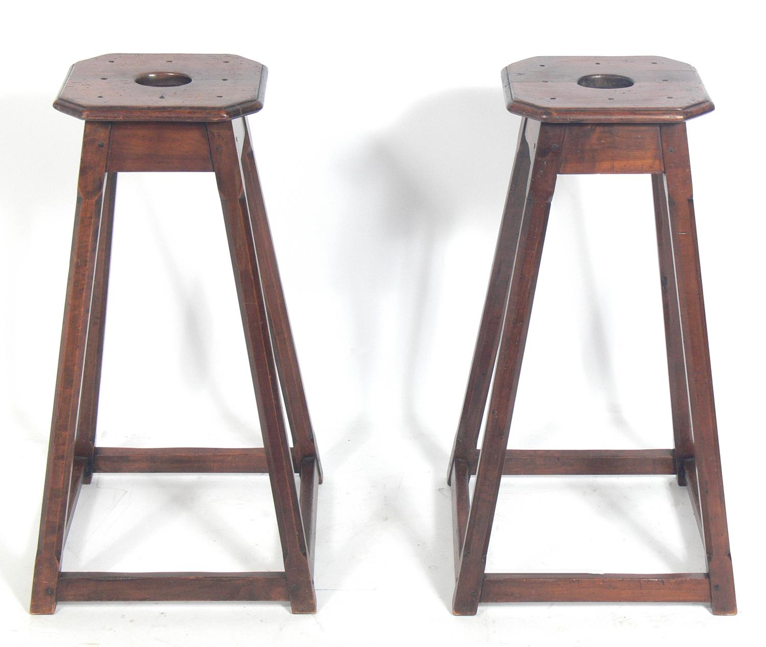 Pair of English bar stools, England, circa 19th century. Solid and sturdy with clean lines and pegged construction. They could also be used as sculpture stands. They retain their warm original patina and have some original graffiti and other old