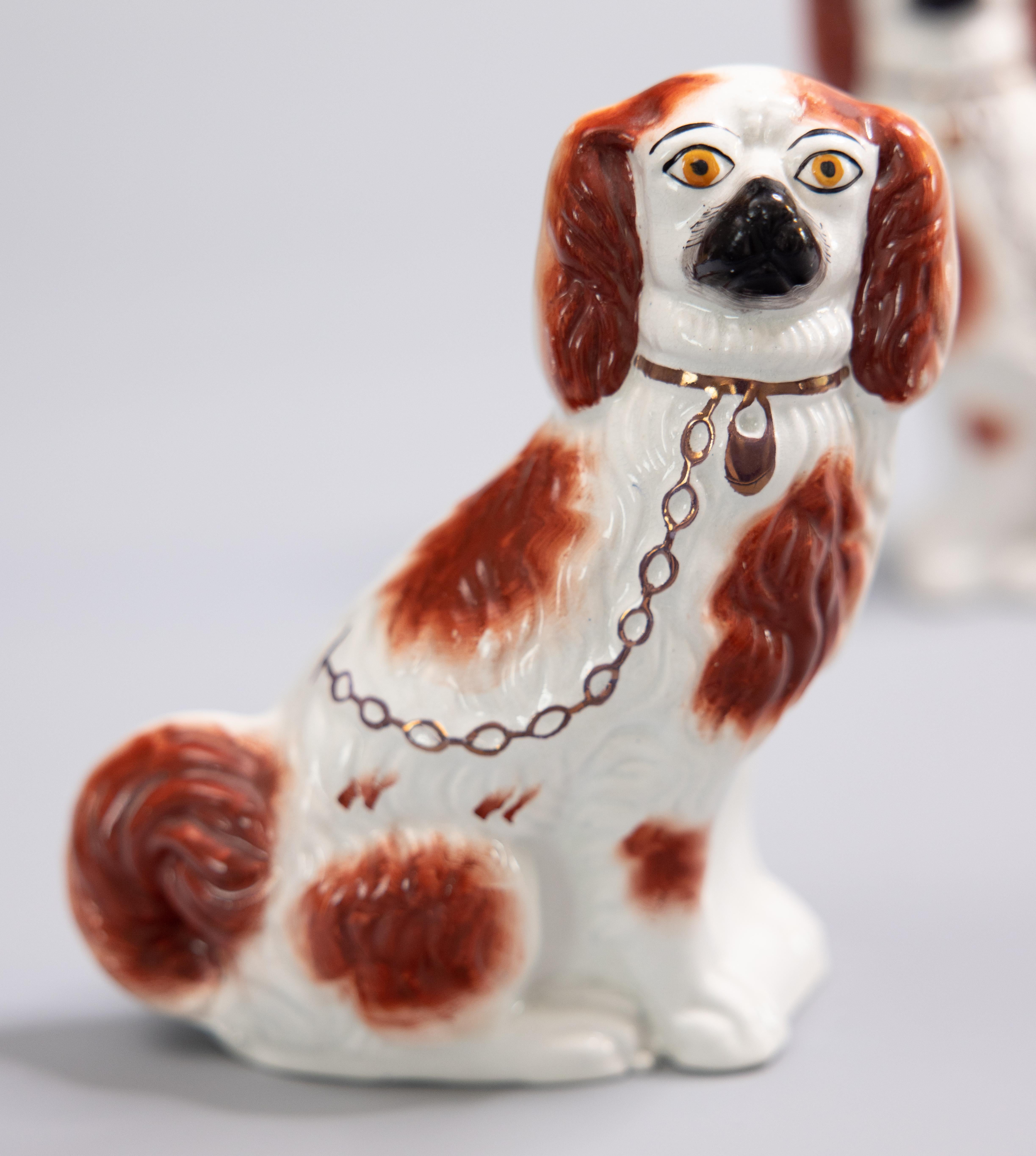 A superb pair of antique 19th-century English Staffordshire russet spaniel dogs. These charming dogs are hand painted with beautiful details, gilt accents, and the sweetest expressions. They are the perfect Victorian pair of dogs for your mantel,