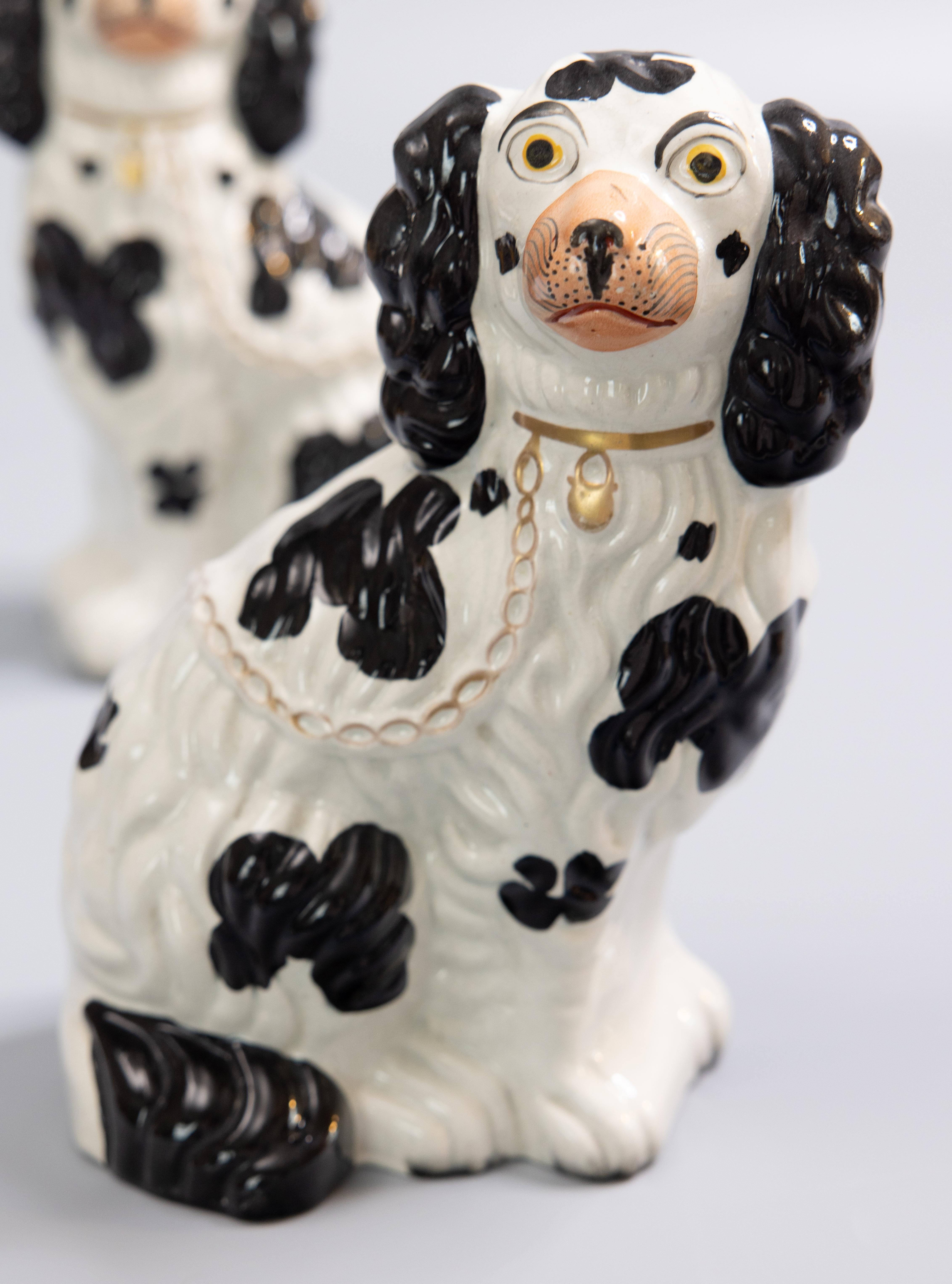 A fine pair of antique English Staffordshire black and white spaniel mantel dogs. These charming dogs are hand painted with lovely gilt details, sweet faces, and are a nice large size. They are the perfect Victorian pair of dogs for your mantel,