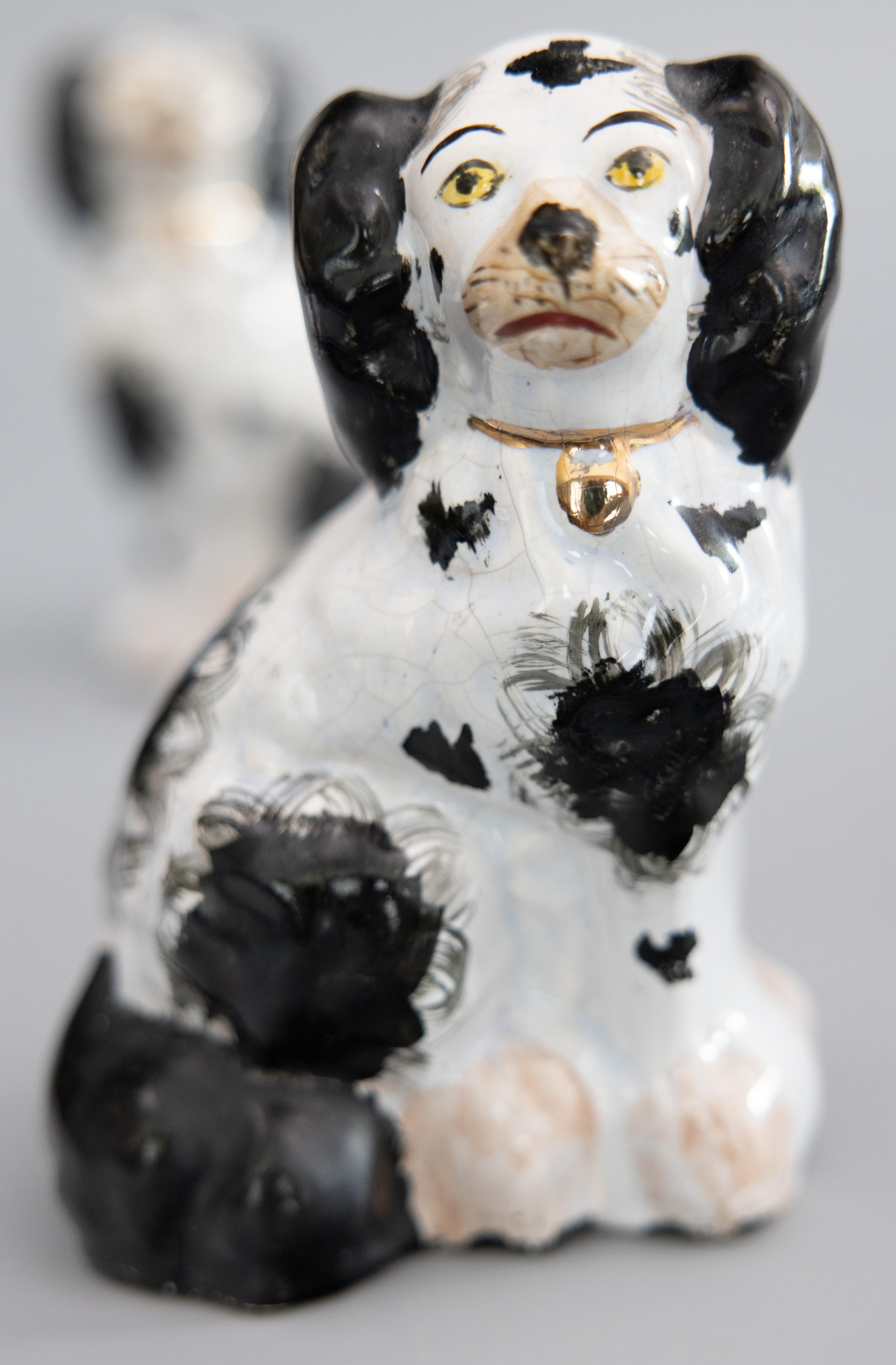 A fine pair of antique English Staffordshire black and white spaniel dogs. These charming dogs are hand painted with lovely gilt details, sweet faces, and are a nice large size. The dogs vary slightly in size; one is approximately 7