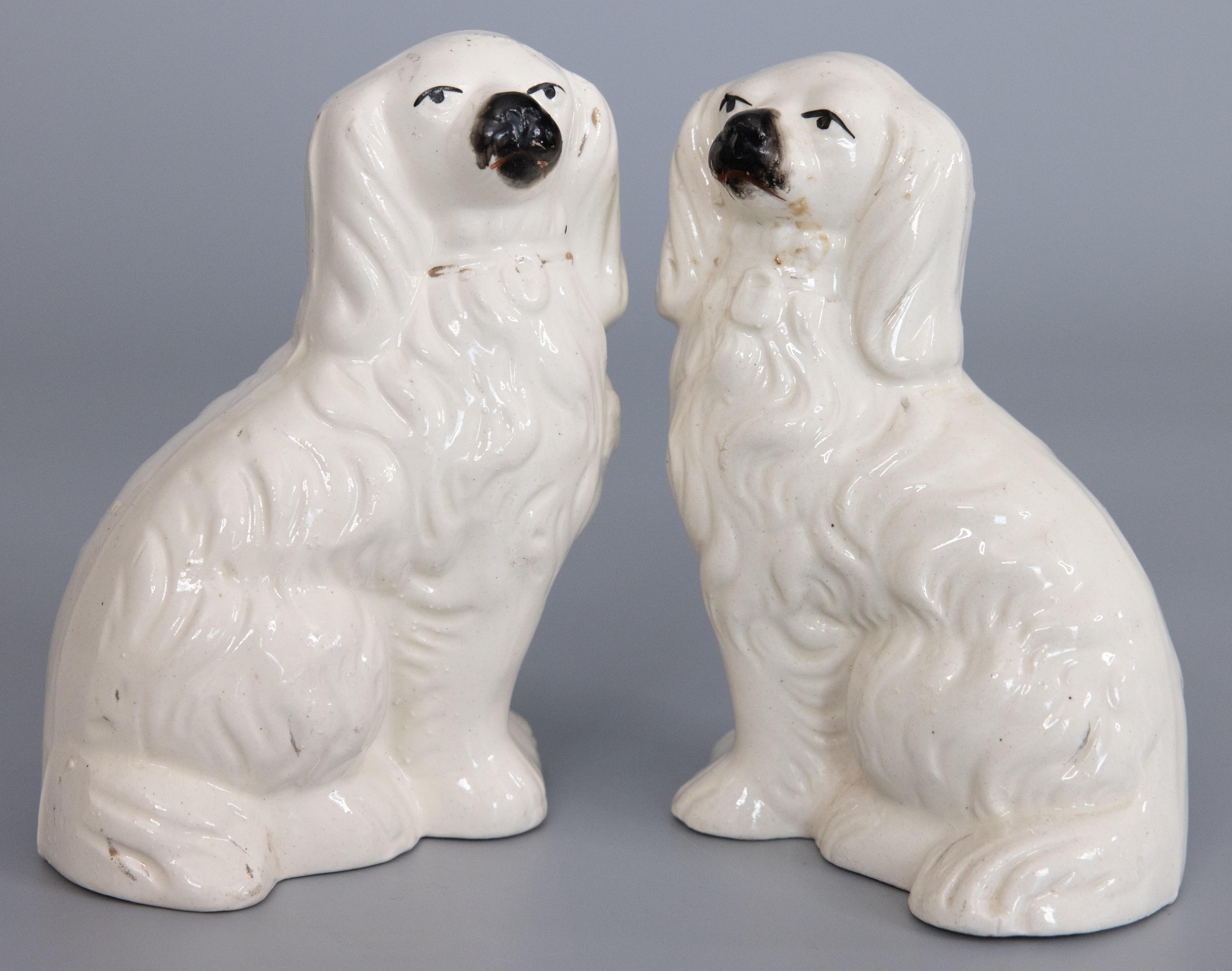 A fine pair of antique 19th-century English Staffordshire spaniel dogs. These charming dogs are hand painted with lovely details and sweet faces. It's hard not to be smitten! They are the perfect Victorian pair of dogs for your home and would make a