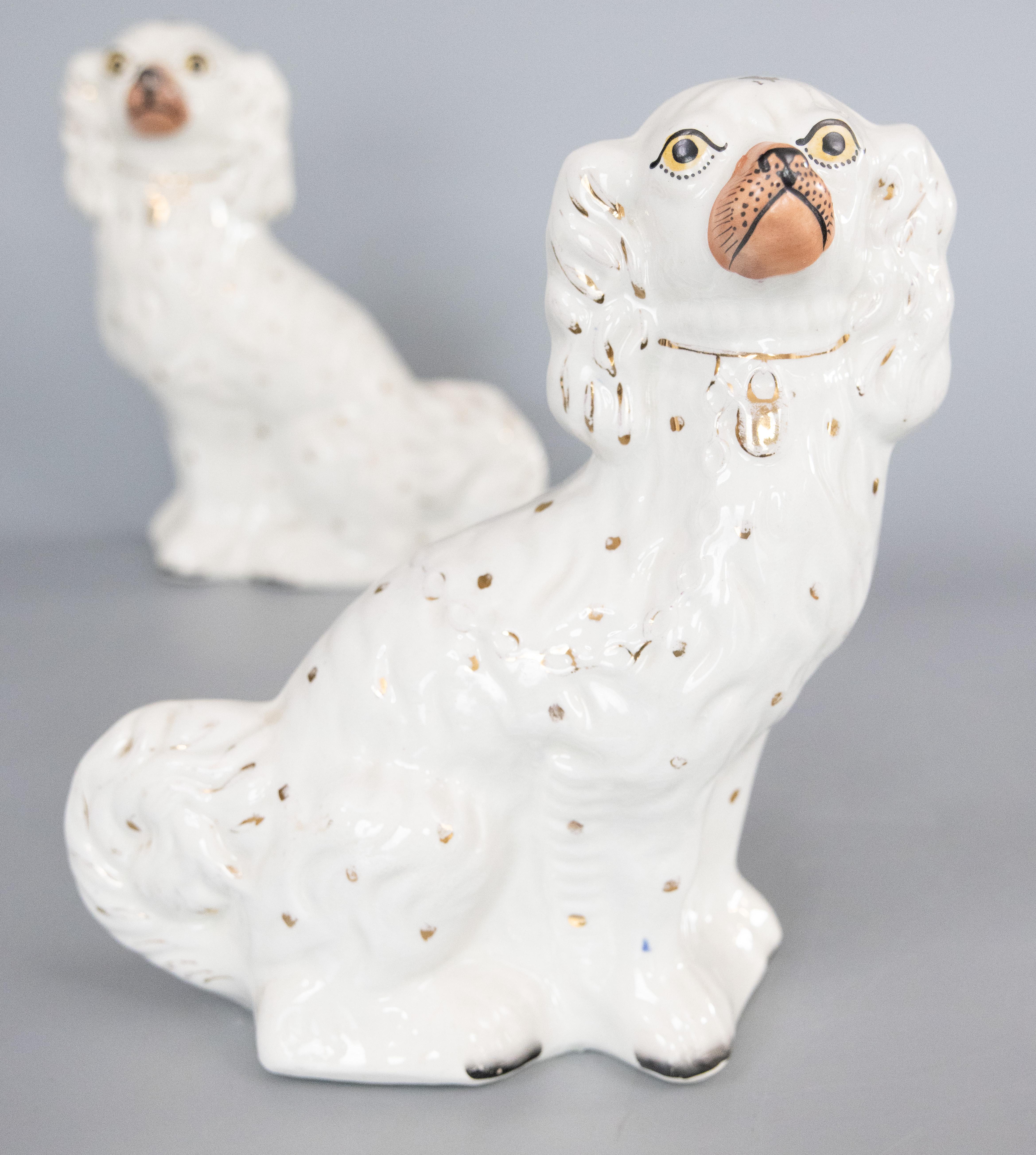 A fine pair of antique 19th-Century English Staffordshire white spaniel dog figurines. These charming dogs are a nice large size, hand painted with lovely details and sweet faces. They are the perfect Victorian pair of dogs for your mantel,