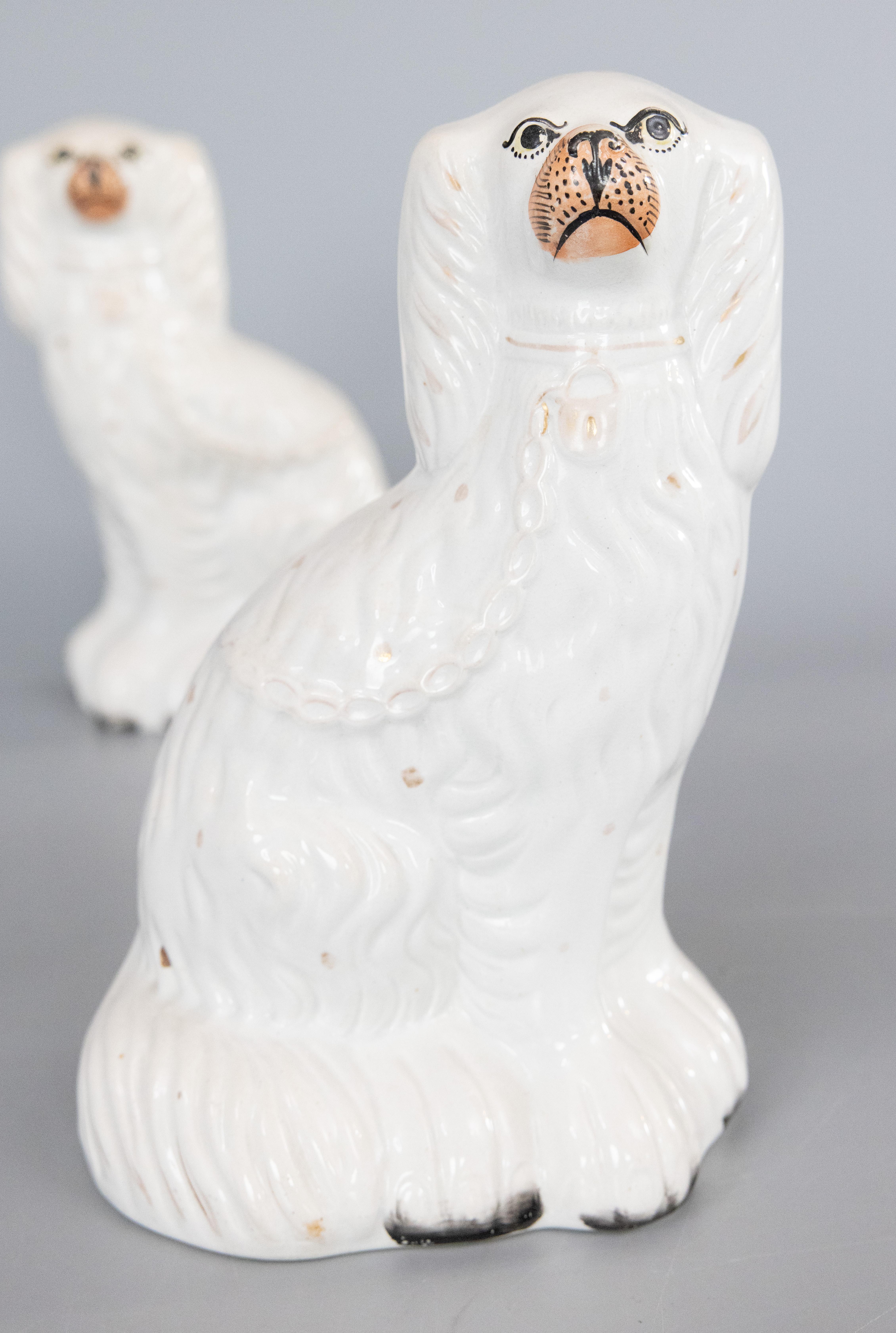 Fino par de figuritas antiguas de perro spaniel blanco inglés de Staffordshire del siglo XIX para la repisa de la chimenea. Estos encantadores perros están pintados a mano con preciosos detalles dorados y dulces caritas. Son la pareja de perros