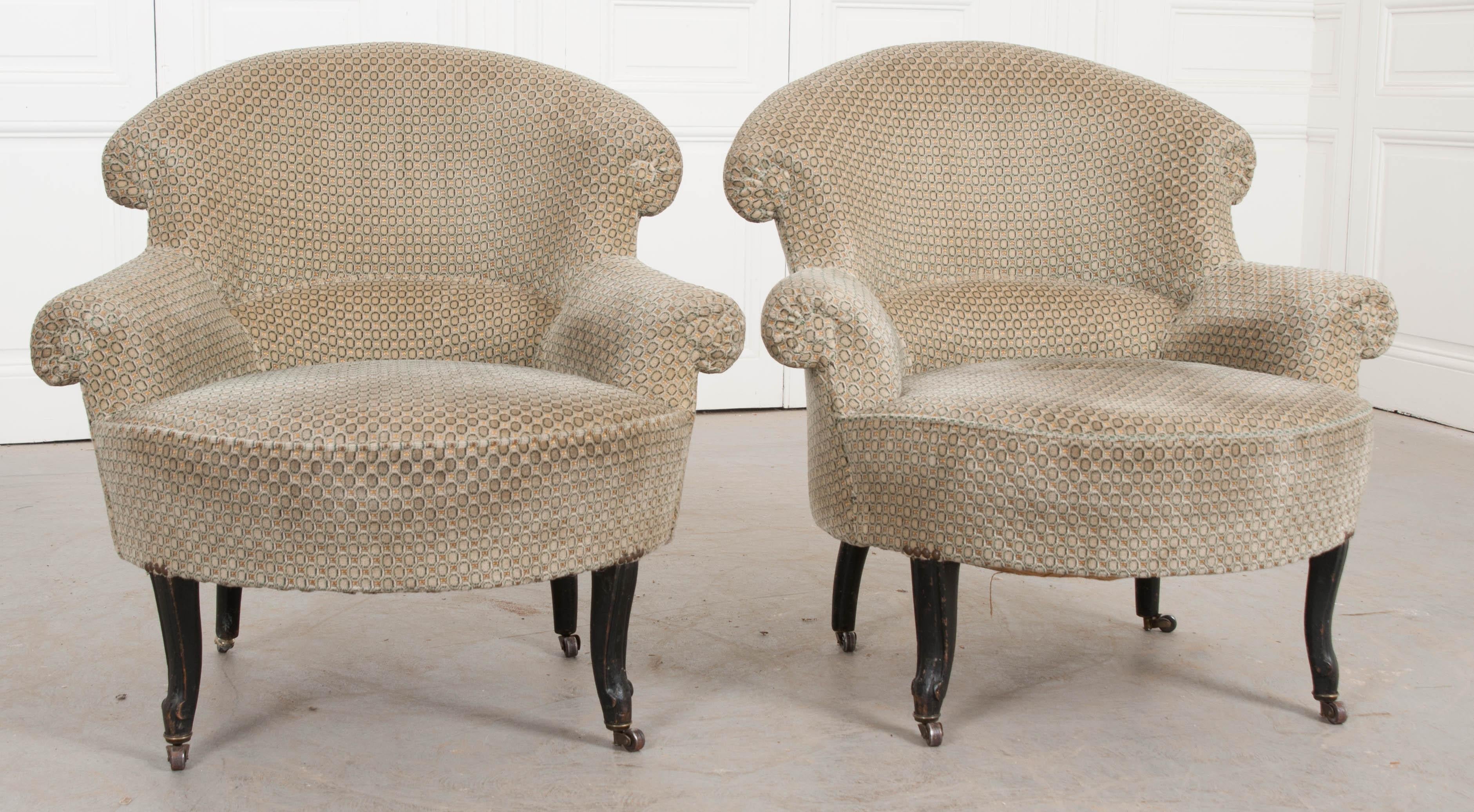 A fantastic pair of upholstered English tub chairs. This comfortable pair was constructed towards the end of the 19th century, circa 1880. They are upholstered in a taupe colored velvet with a repeating cut-emerald shaped design. The upholstery is