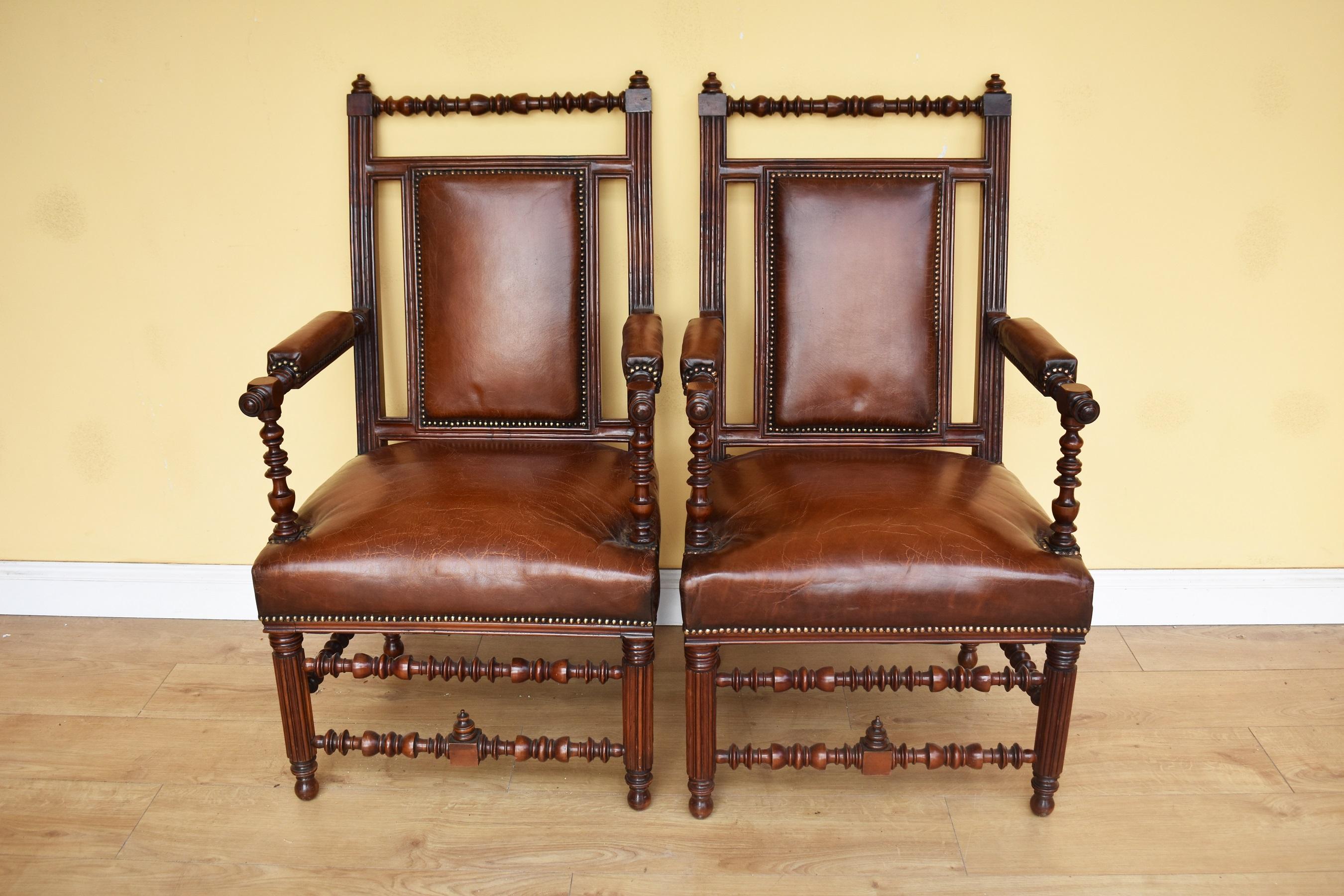 For sale is a good quality pair of 19th century Victorian reformed Gothic walnut and leather upholstered armchairs. Both armchairs have ornately turned frames and stretchers, and have been made in the manner of Bruce Talbert. The chairs are