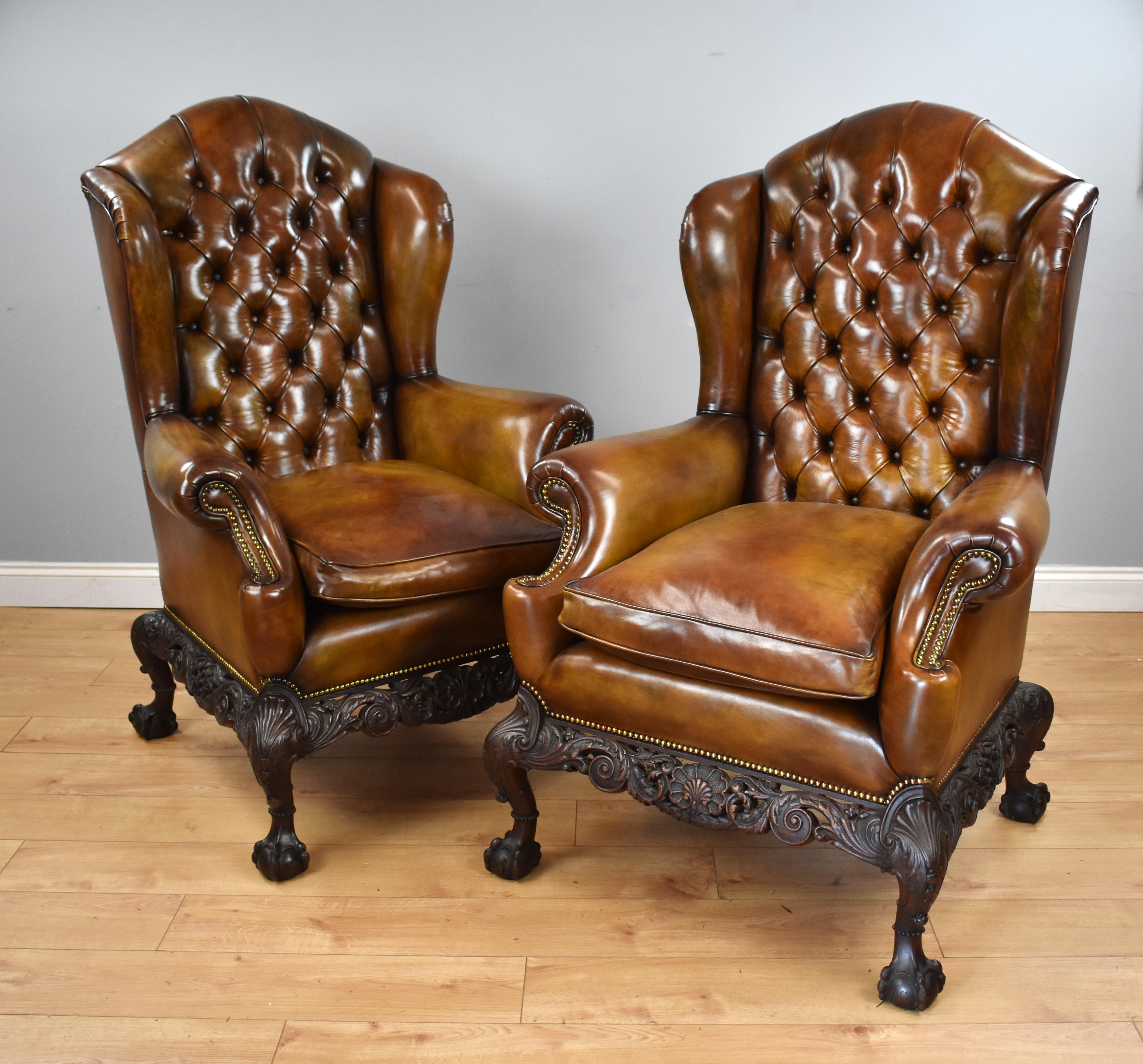 For sale is a top quality pair of Victorian hand dyed leather wing back armchairs, each having arched tops above deep buttoned backs, flanked by wings, with a cushion below, with a scroll arm on either side, each with brass studding. Both chairs
