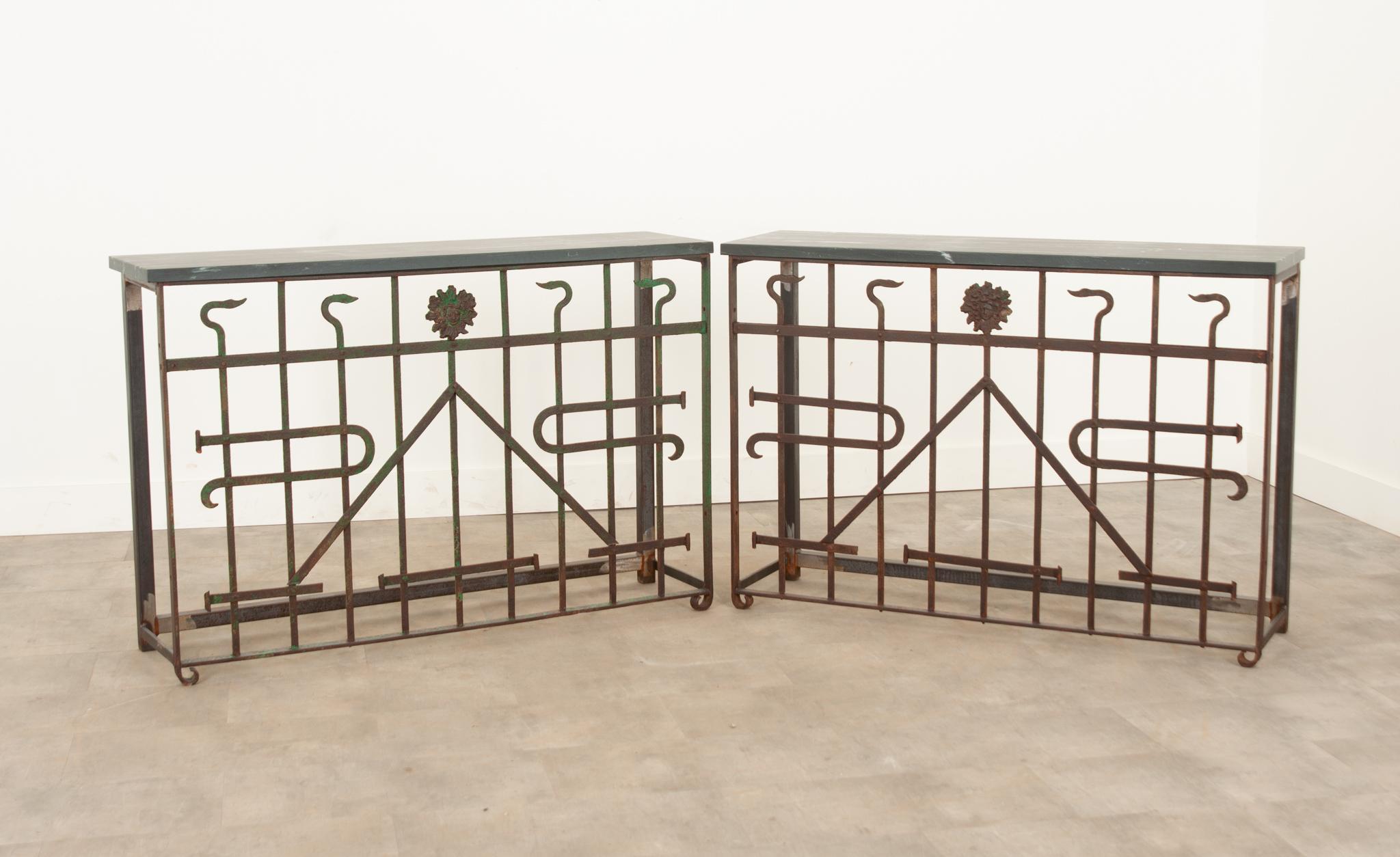 This newly composed pair of  consoles were recently crafted from 19th Century iron panels from Europe and topped with a fabulous piece of charcoal stone with white veining. The iron was painted a vibrant green once and has gained a perfect patina.