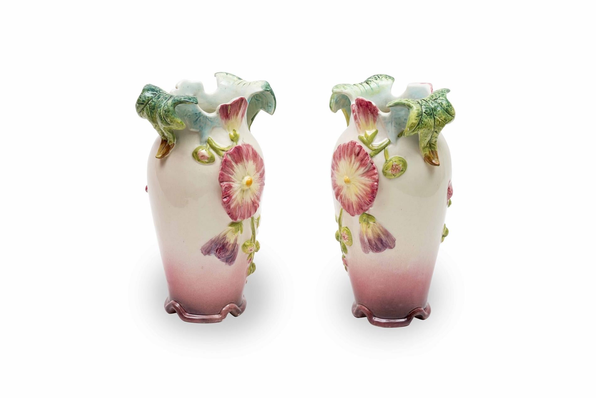 Pair of pink, purple and blue floral vases. The belly is decorated with a branch of flowers. A slight indentation at the bottom allows a good stability to the whole. The vase ends with a neck that is cut according to the petals of the flowers and,