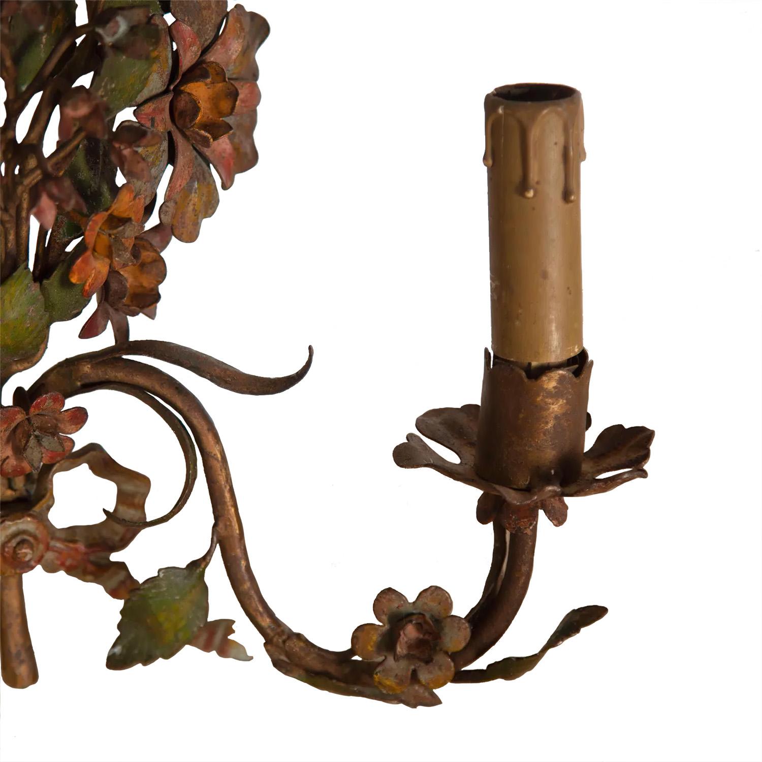 A pair of metal two arm wall lights with decorative flora and fauna and a good time worn patina. These pieces have been rewired and PAT tested to Uk standards.
   