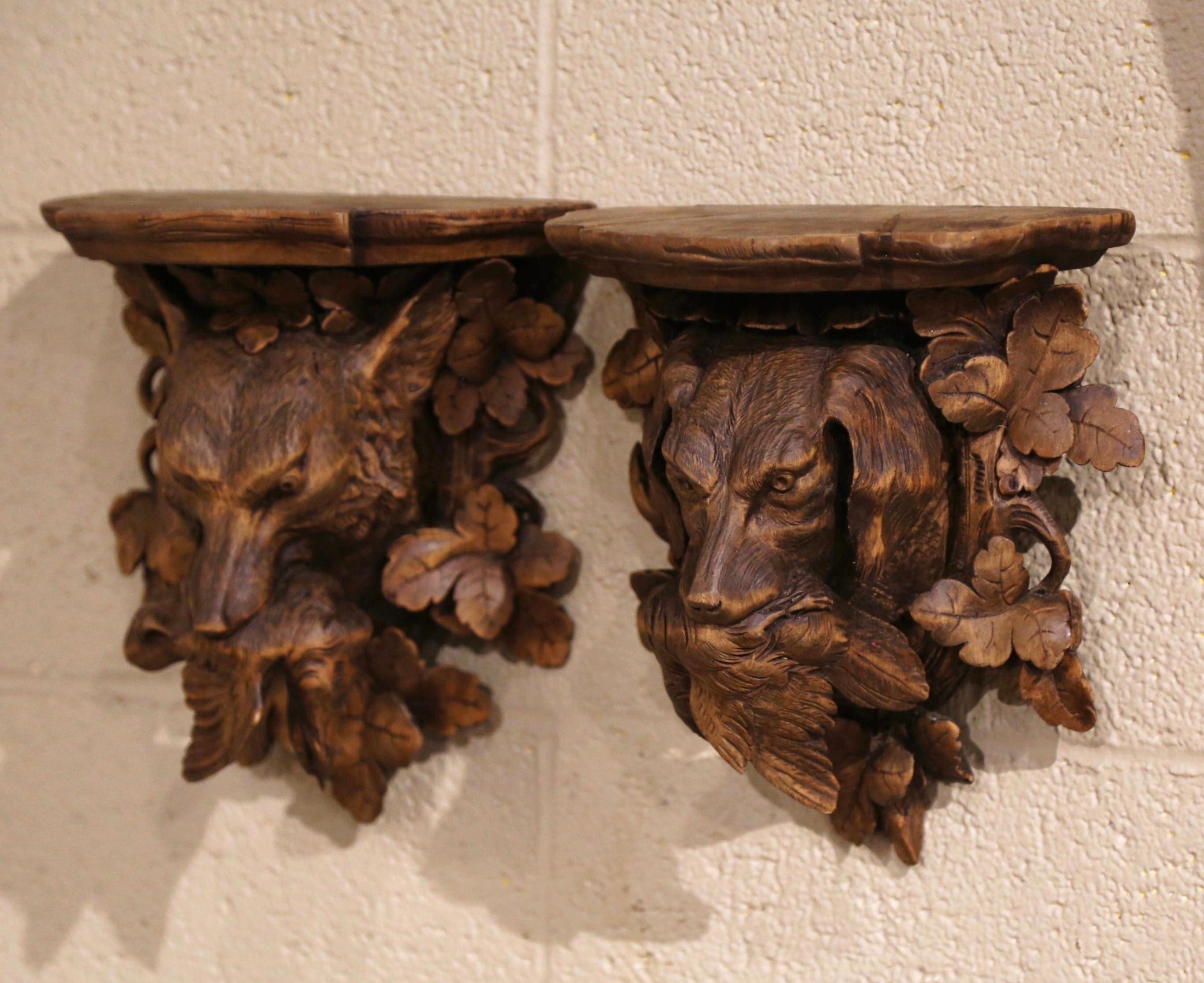 This beautifully antique wall brackets were carved in the Alps Mountains of France, circa 1870. Half circle in shape, each fruitwood shelf console features fine hand carved nature motifs including a dog figure holding a bird in his mouth,