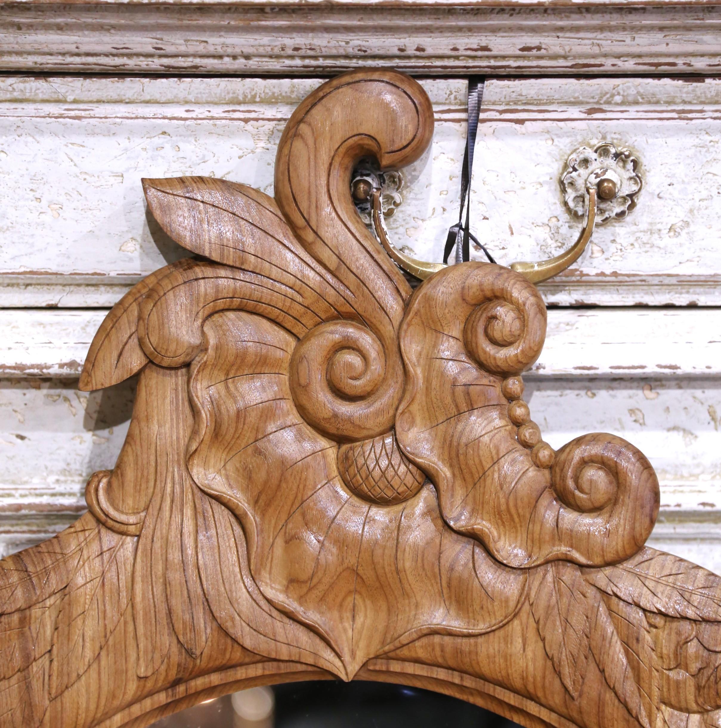 Fabriquée en France vers 1890, cette élégante paire de miroirs ovales présente de superbes cadres en chêne sculptés à la main avec des motifs naturalistes d'acanthes enroulées, de grappes de raisin et de feuilles de vigne. Chaque cadre est richement