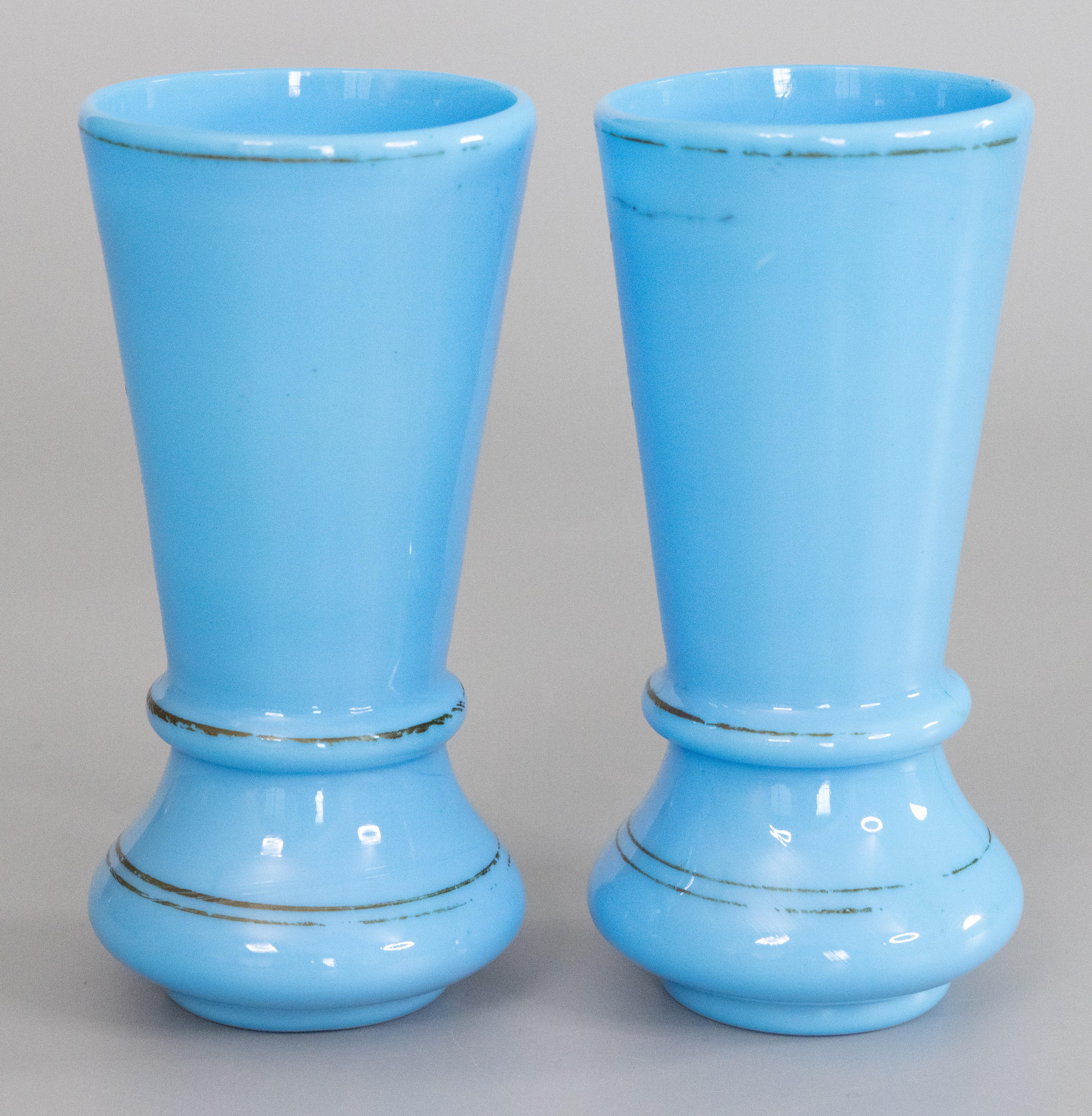 A gorgeous pair of antique French Napoleon III blue opaline glass vases with hand painted gilt decoration. They are a stunning color and stylish shape, perfect for the modern home.