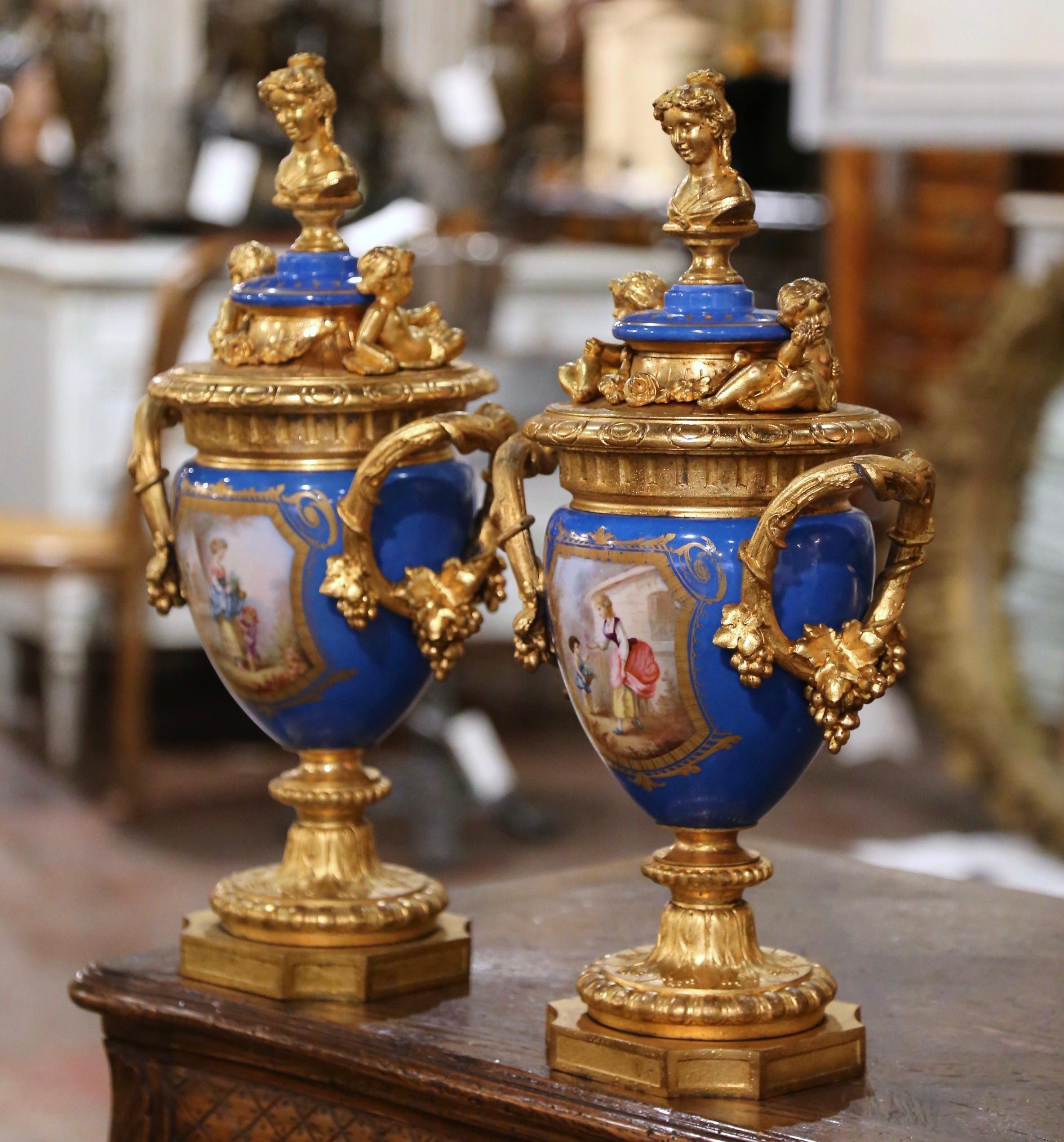 Decora un caminetto o una consolle con questa importante coppia di urne di Sèvres in porcellana e bronzo. Creato a Parigi, in Francia, intorno al 1870, ogni imponente vaso poggia su una base quadrata in bronzo con angoli tagliati e decorati con