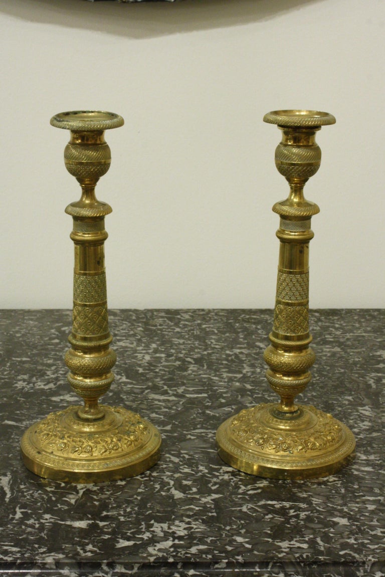 A pair of very finely-chased French brass candlesticks, circa 1870 in the neoclassical style (could be electrified as table lamps).  Bases are decorated with rose vines.