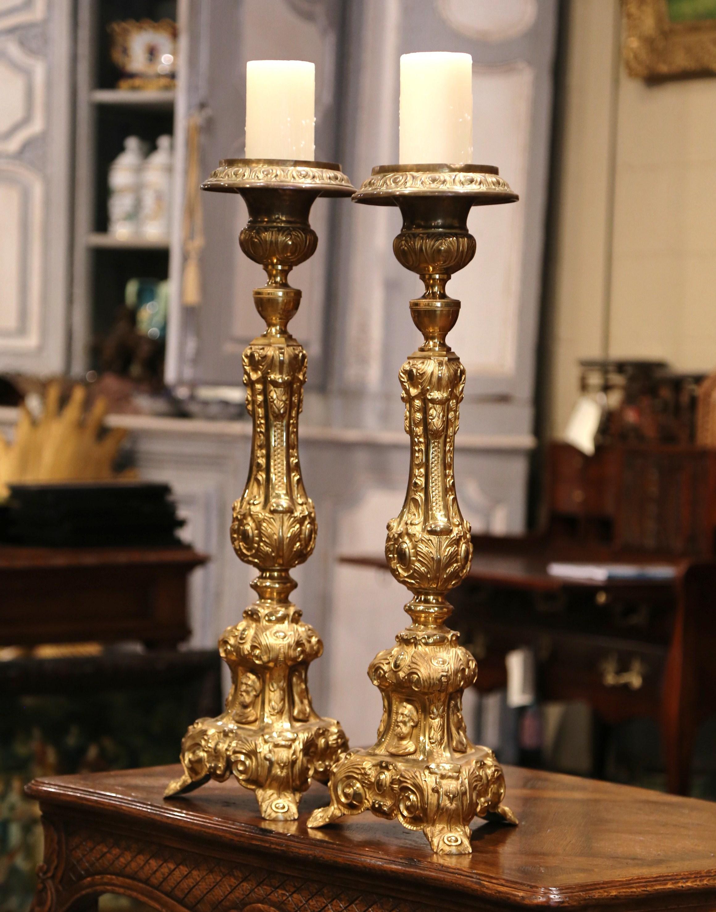 These brass candlesticks were found in a private chapel near Lyon, France. Crafted circa 1860, each pricket sits on small curved feet with three sides embellished by repousse decor. Both tall candleholders have three religious medallions with God,