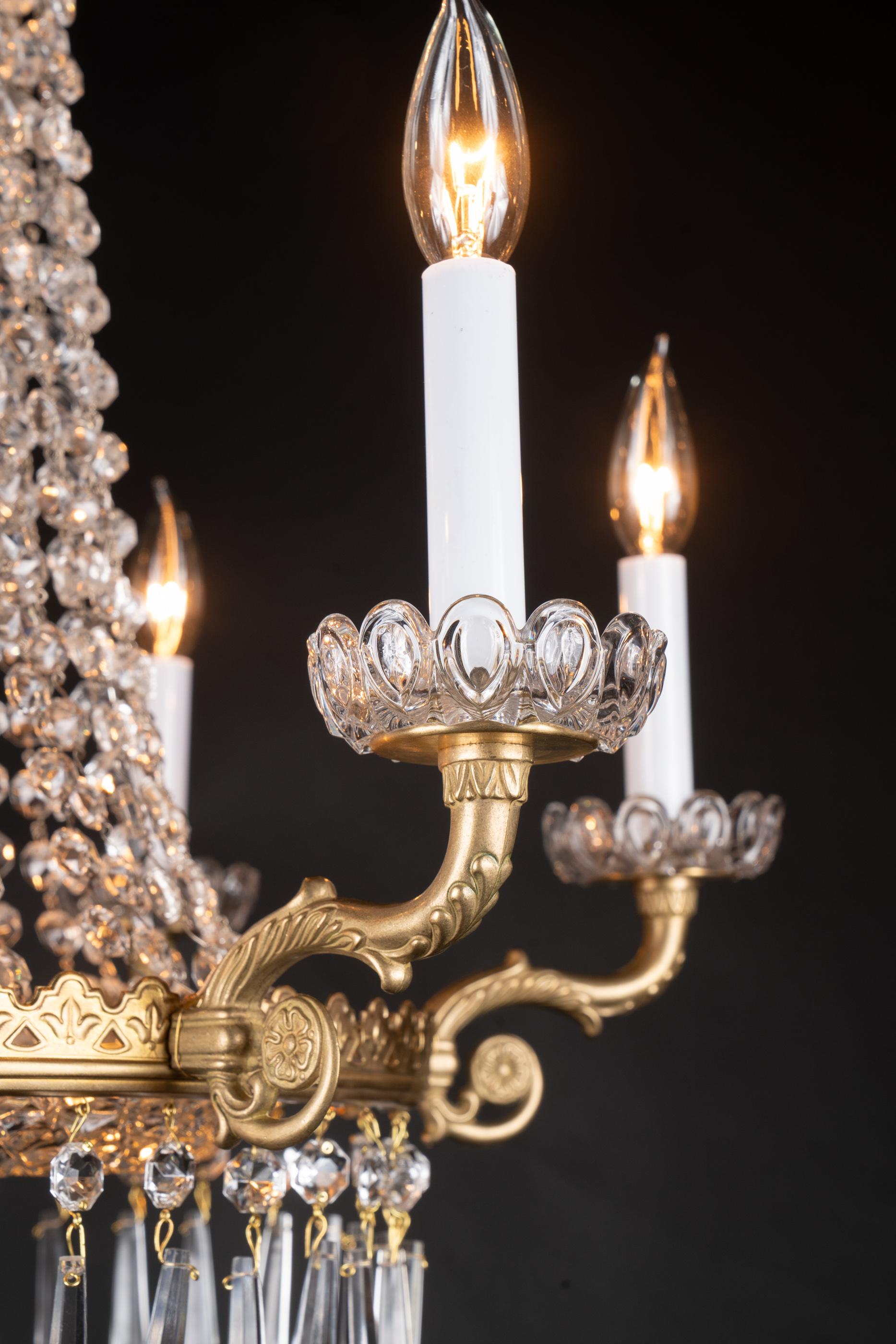 Questa splendida coppia di lampadari francesi del XIX secolo è realizzata in bronzo in stile Impero. In particolare, ognuno di essi è caratterizzato da un piatto centrale in cristallo di immacolata bellezza, affiancato da una dettagliata corona di