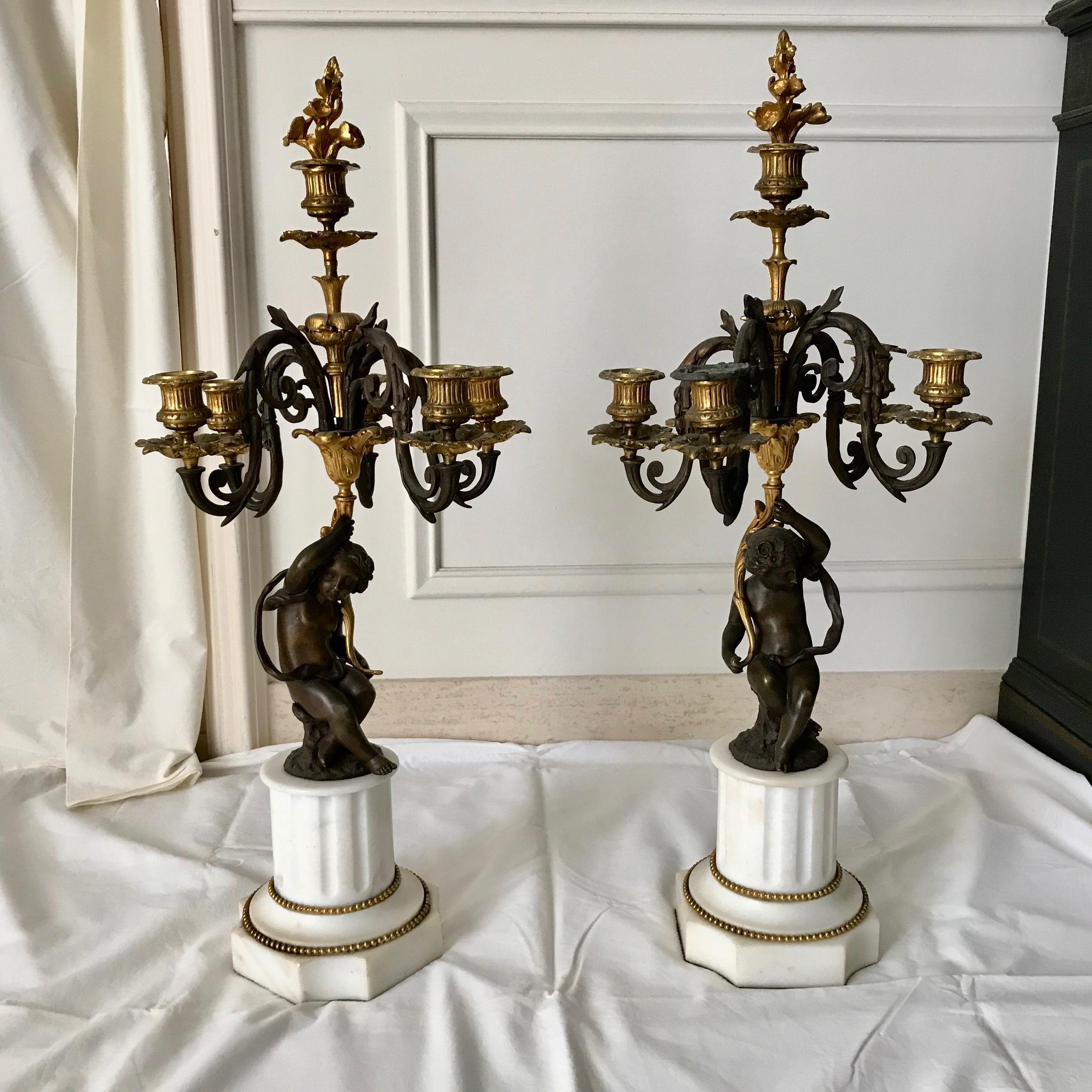 Finely cast in dore' and patinated bronze raised upon marble plinths.
The candelabras are a stately size. In addition: the top portions are removable.
Candle snuffers- as photographed.
Measurements include snuffer inserts which are original.