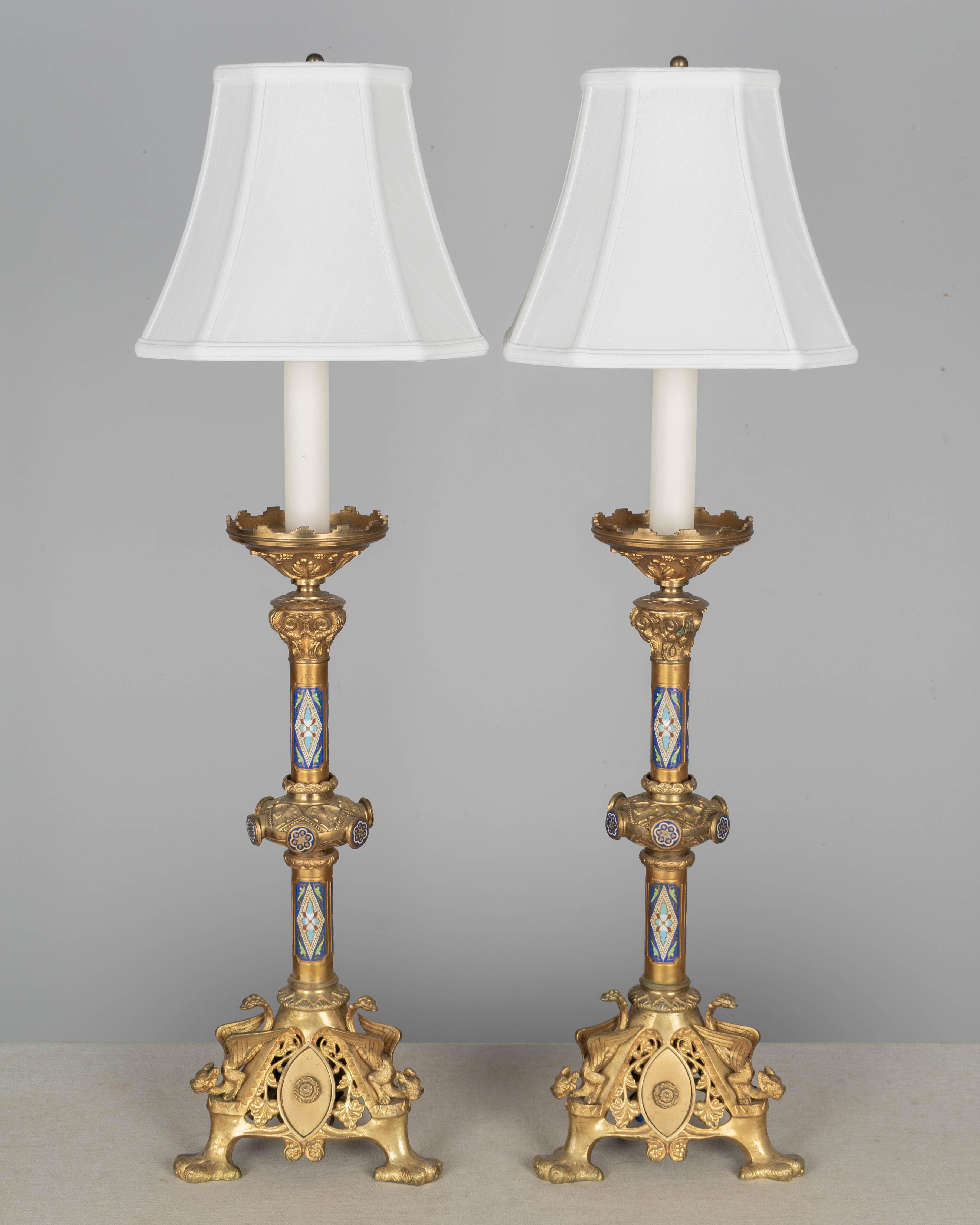 Coppia di lampade a candeliere alte in bronzo fuso dorato francese con decorazioni colorate in smalto champlevé. Base a triangolo con fantastici draghi alati e piedi ad artiglio. Qualità e condizioni eccellenti con colori brillanti. Un tempo
