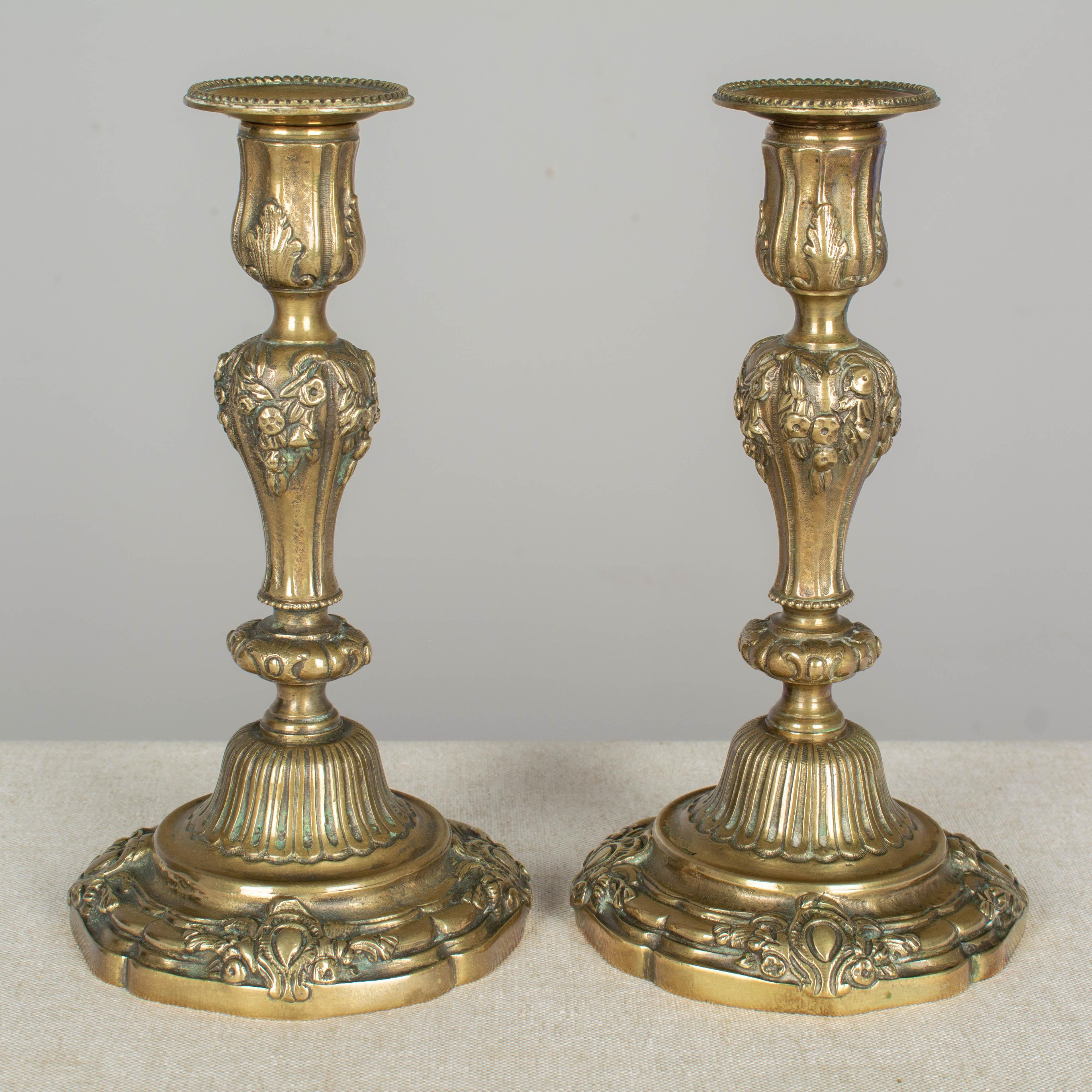 A pair of 19th century French Louis XV style cast bronze candlesticks. Good quality heavy casting with nice floral details.