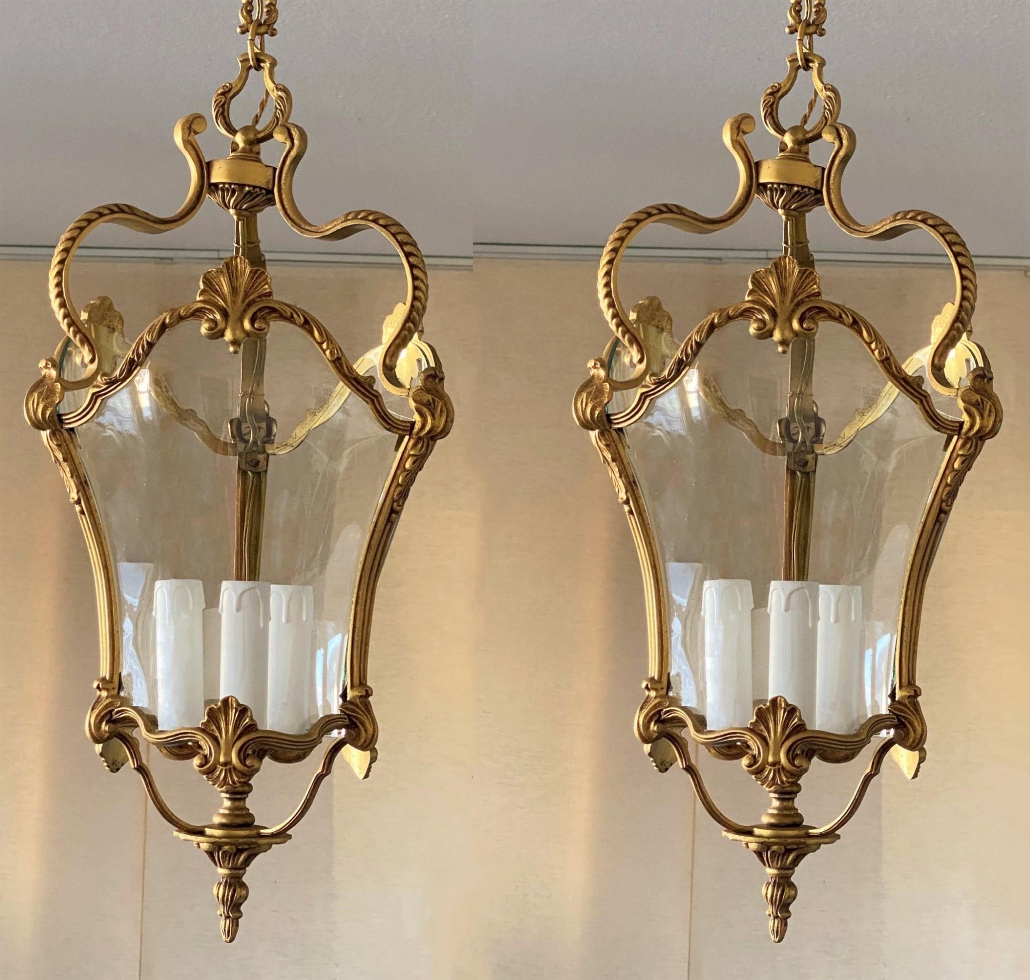 A pair of fine antique Art Deco bronze doré and crystal lanterns, France, early 20th century. Finely cast, hand-chassed and hand-chiseled French fire-gilded bronze with crystal arched crystal panels and a central three-light candelabra cluster. Due
