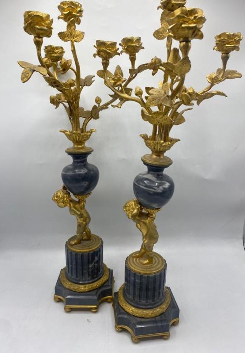 Paar französische Bronze-, Ormolu- und Marmorkandelaber aus dem 19. Diese hohen Kandelaber stellen Putten dar, die mit Rosen gefüllte Vasen hochhalten. Frankreich, 1801-1900. Maße: 19