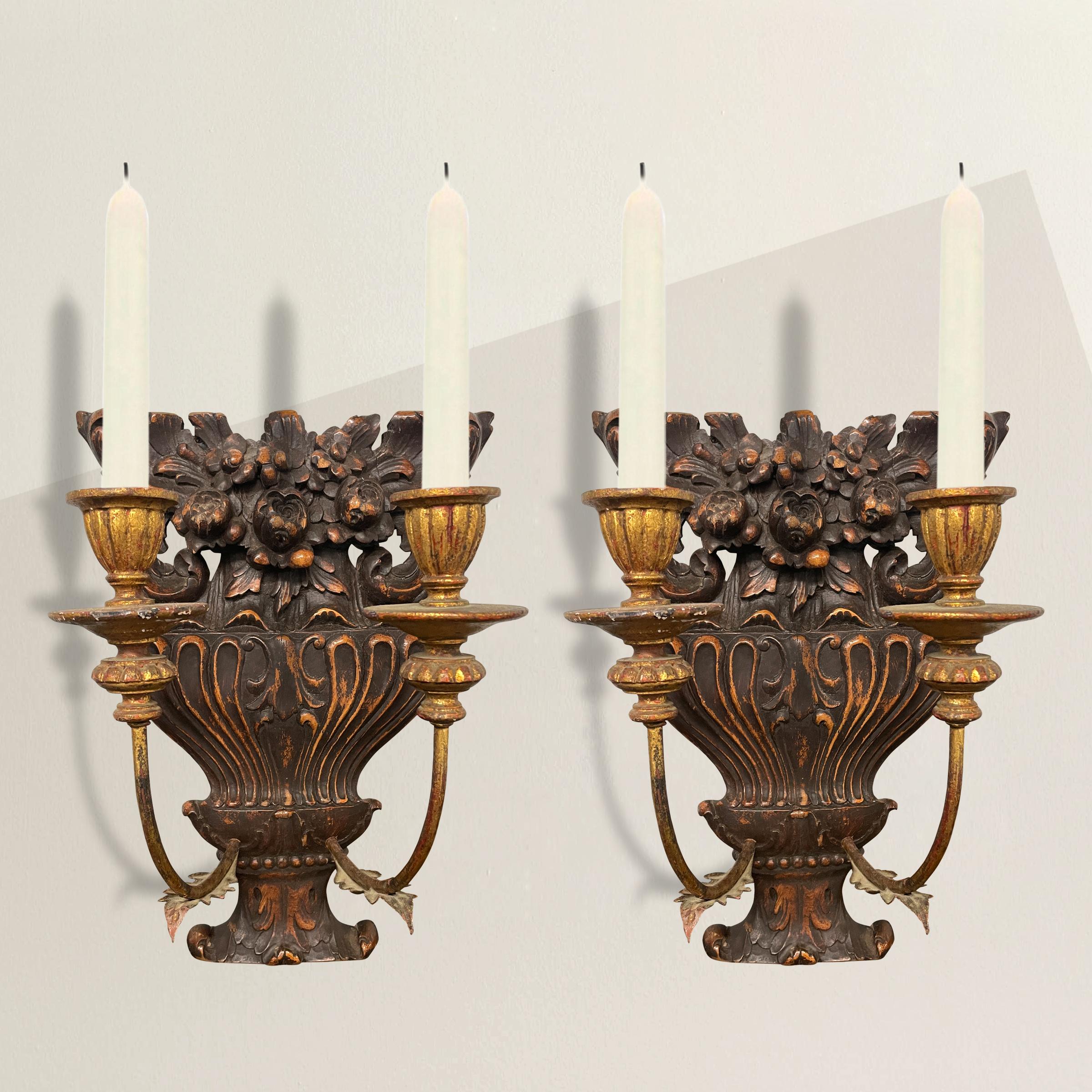 A charming pair of mid-19th century French candle sconces with carved floral-potted urn backplates, and gilt metal and wood arms. Sconces could be electrified for an additional fee.